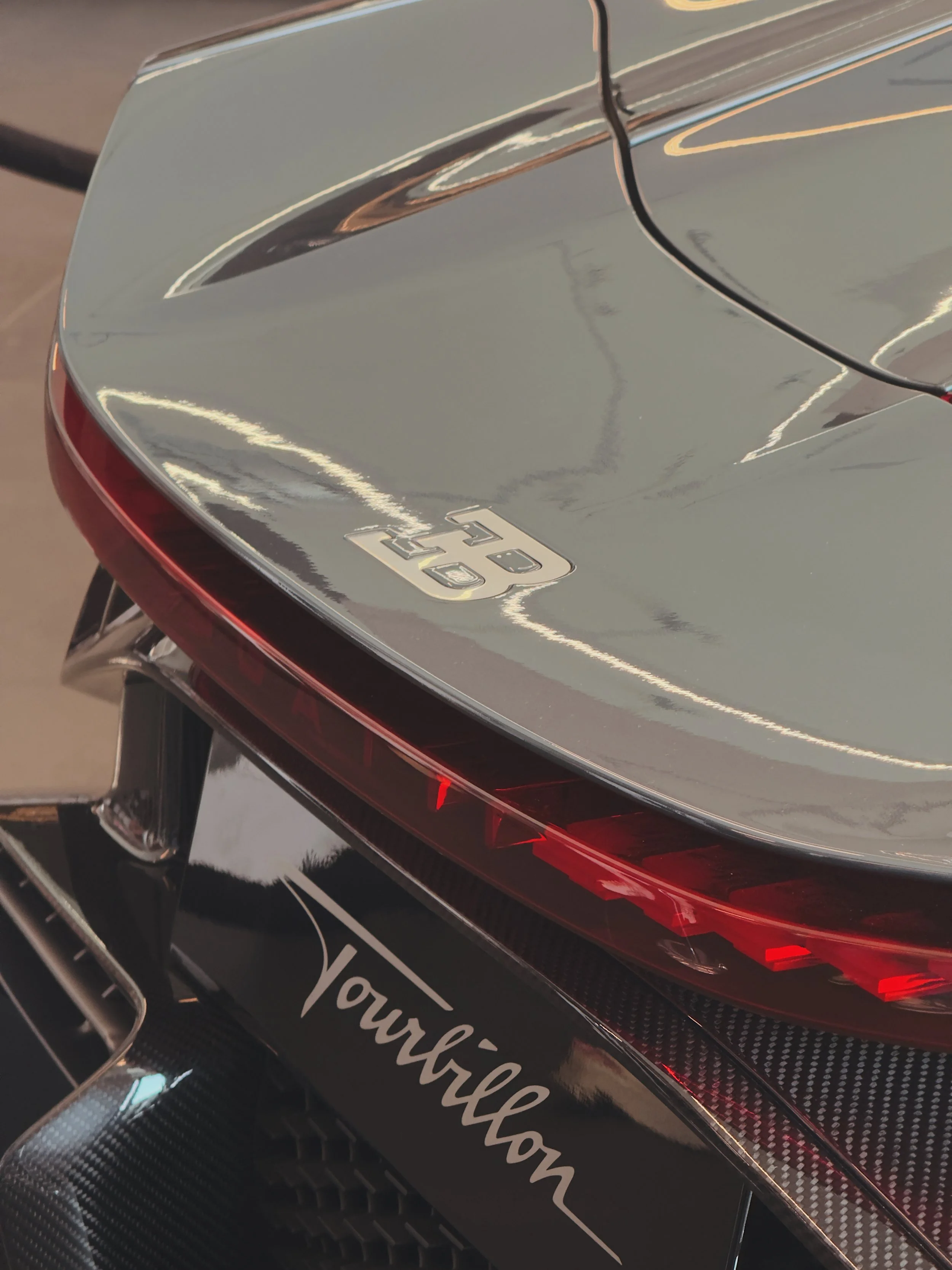 Close-up photo of a Ferrari with a silver finish, featuring the Ferrari logo and the word 'Tournillion' on the rear part of the car.