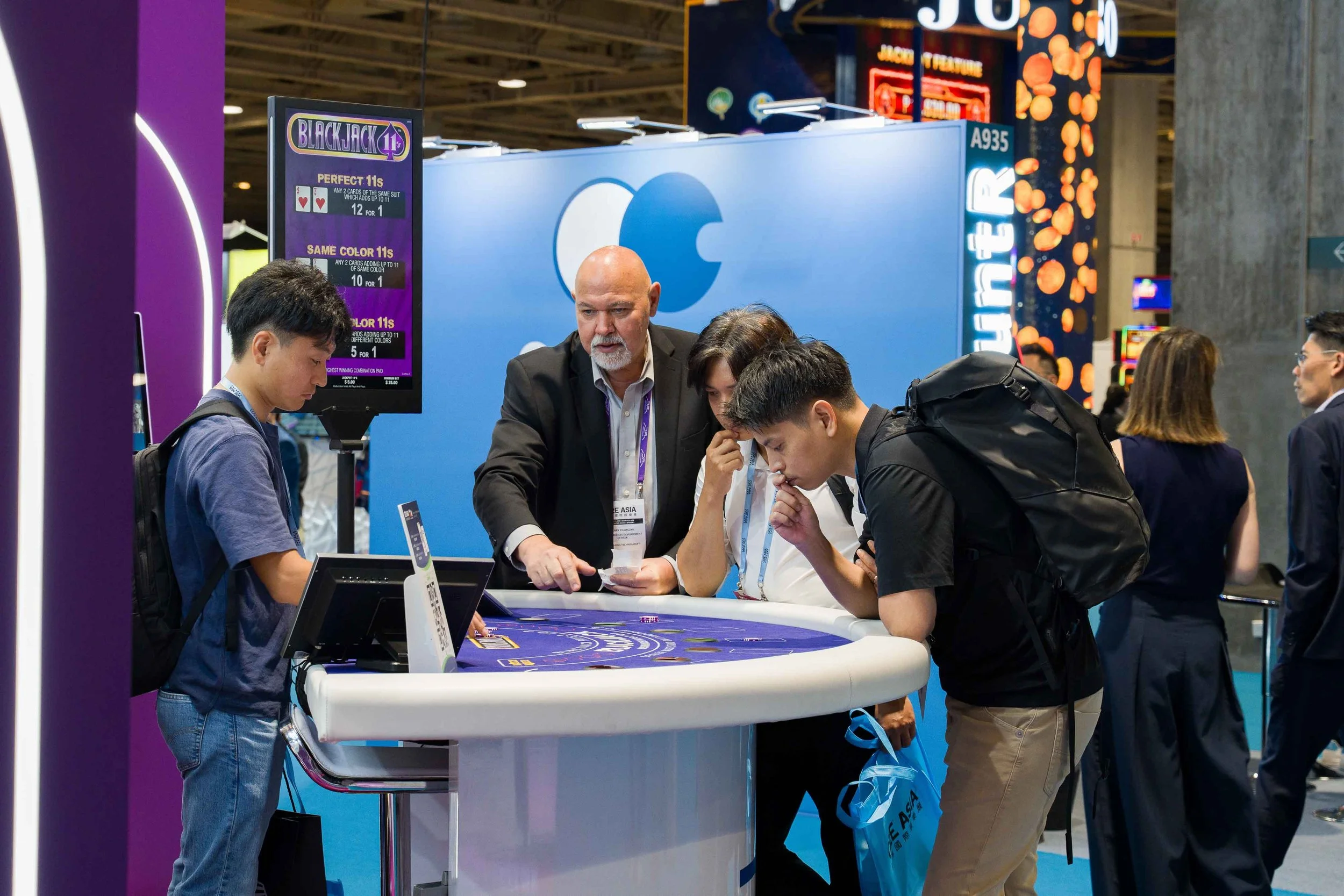 Exhibitor product demonstration photography in Macau showing client interaction during a trade show. 澳門參展商產品展示攝影，紀錄展會中的產品示範、客戶互動及商務交流。