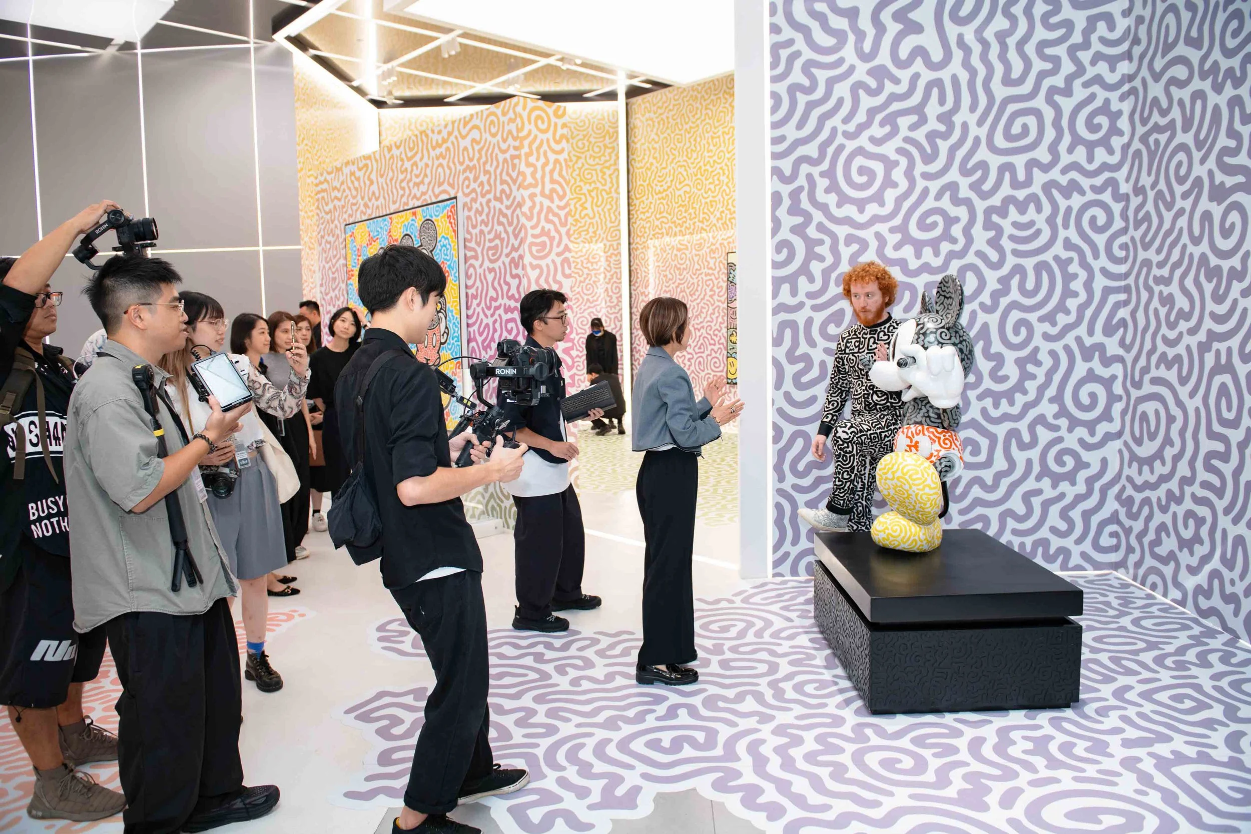 Brand activation event coverage in Macau, capturing a guided guest experience inside a branded art exhibition space by Crio Media.Crio Media 於澳門拍攝品牌體驗活動，紀錄藝術展覽空間、現場導覽、賓客互動及品牌活動氣氛。