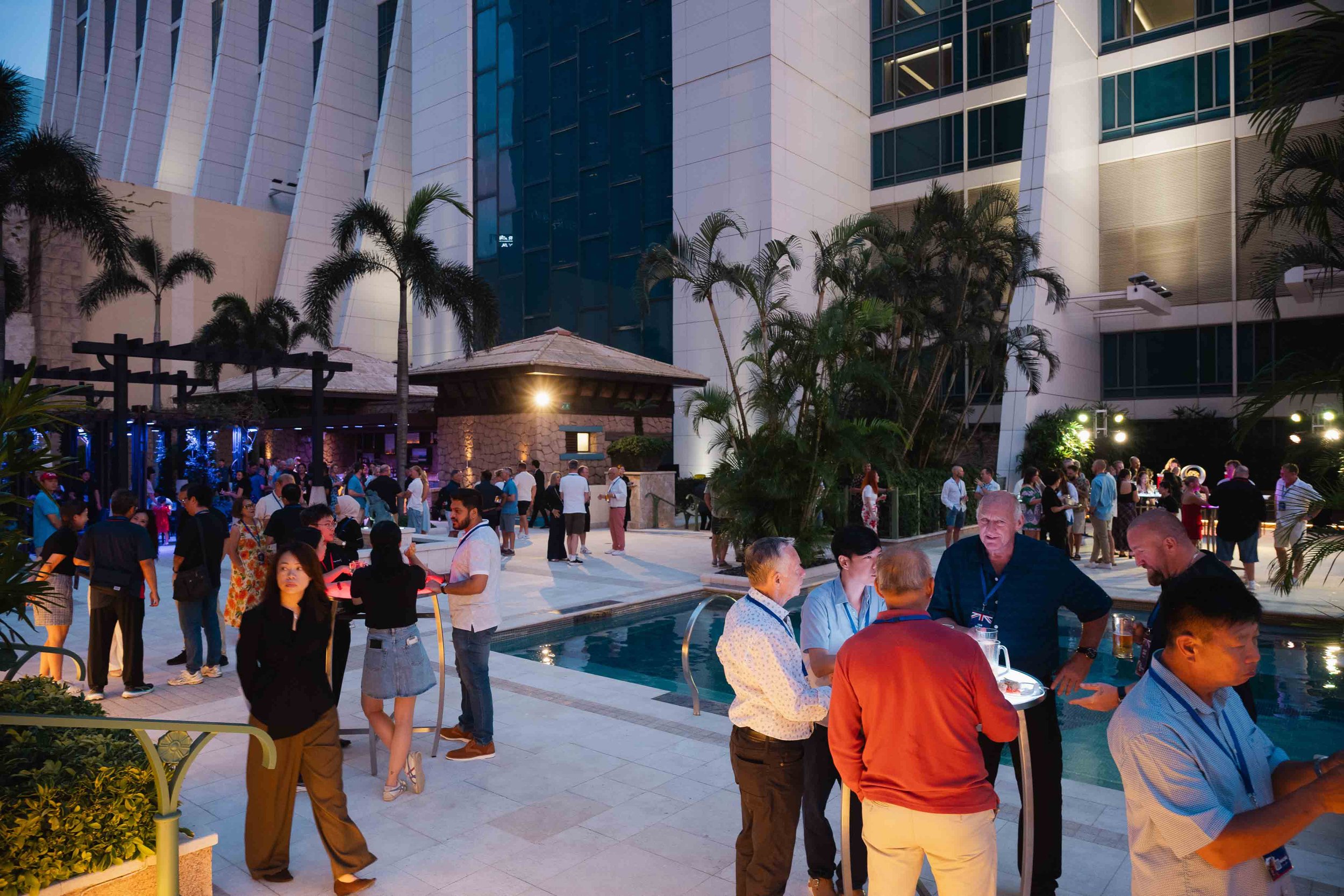 Hospitality and VIP event coverage in Macau, capturing a poolside cocktail reception with guests networking at an evening event.澳門酒店及 hospitality 活動攝影，紀錄池畔 cocktail reception、賓客交流、社交氣氛及晚間活動場景。