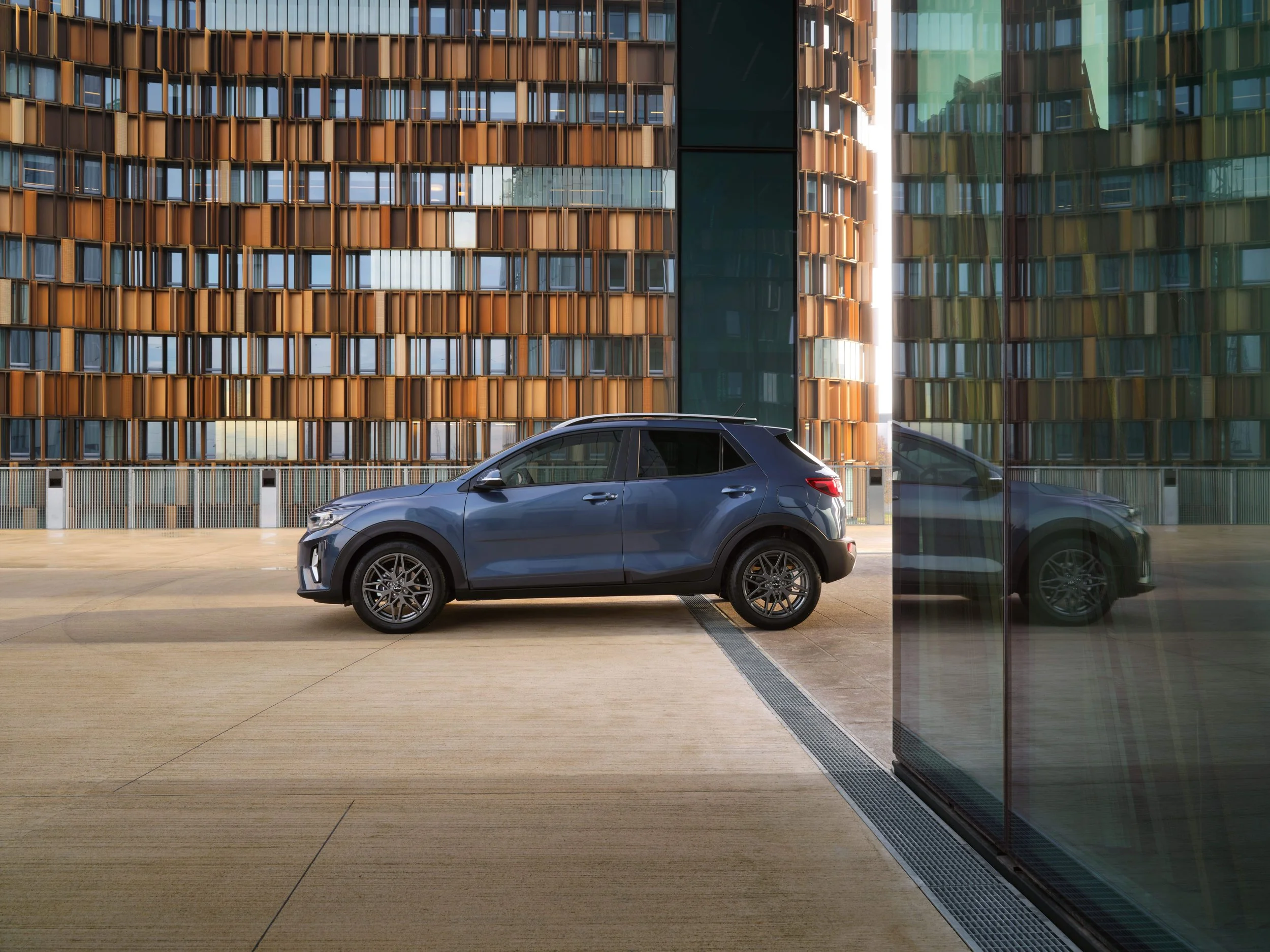 Auto blu parcheggiata in un'area urbana con edifici moderni sullo sfondo