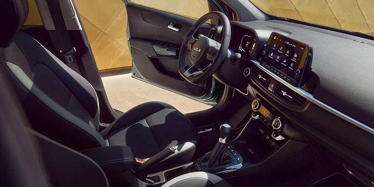 Interno di un'auto ibrida con volante, sedile, schermo digitale e comandi.