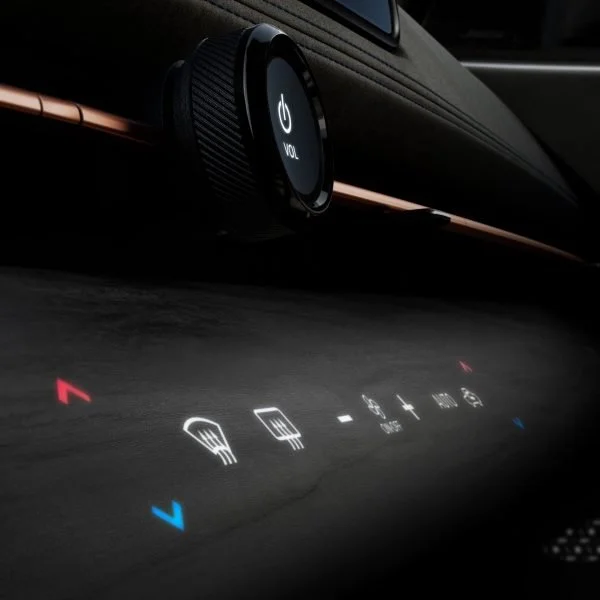 Pannello di controllo di un'auto con comandi touch, inclusi riscaldamento, volume, e clima, con luce blu e rossa.