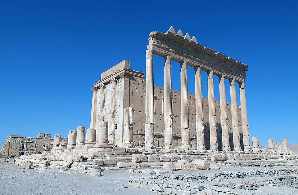 Ancient Greek temple ruins with tall columns under a clear blue sky, Palmyra, Syria.