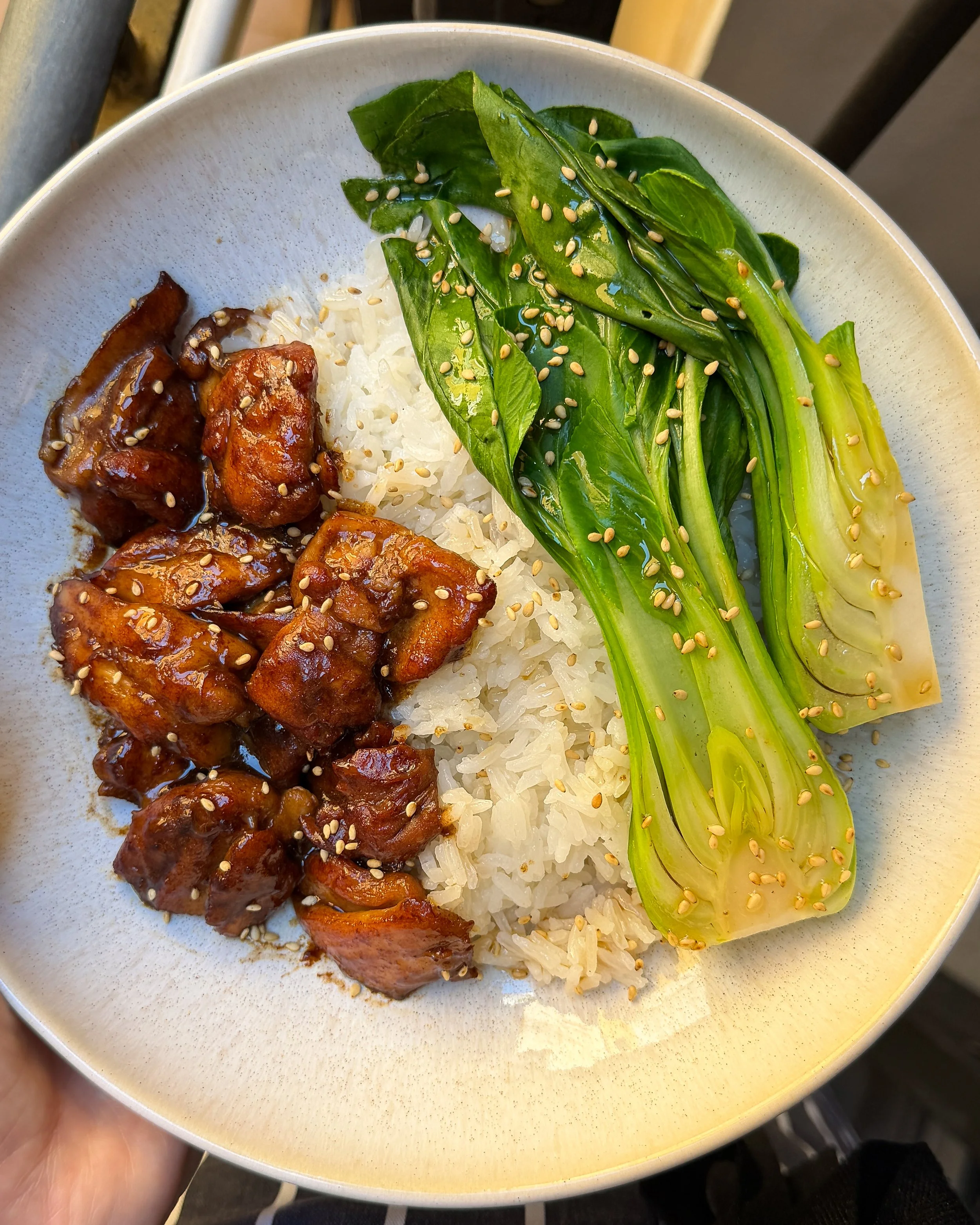 Sticky soy-glazed chicken rice bowl with bright green vegetables, inspired by Chinese takeout.