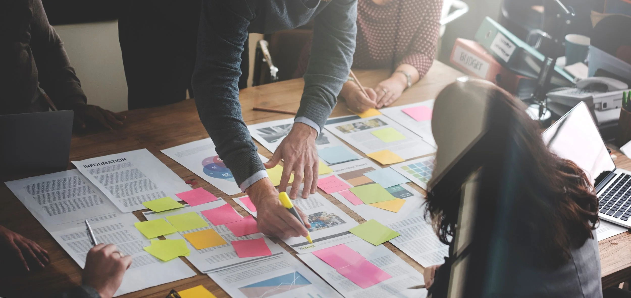 A picture of a team collaborating at a table with documents.