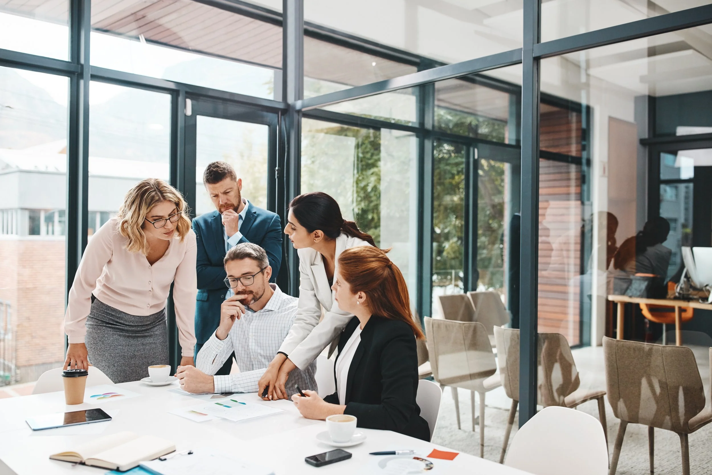 Picture of a group of professionals collaborating around a table in a modern office.
