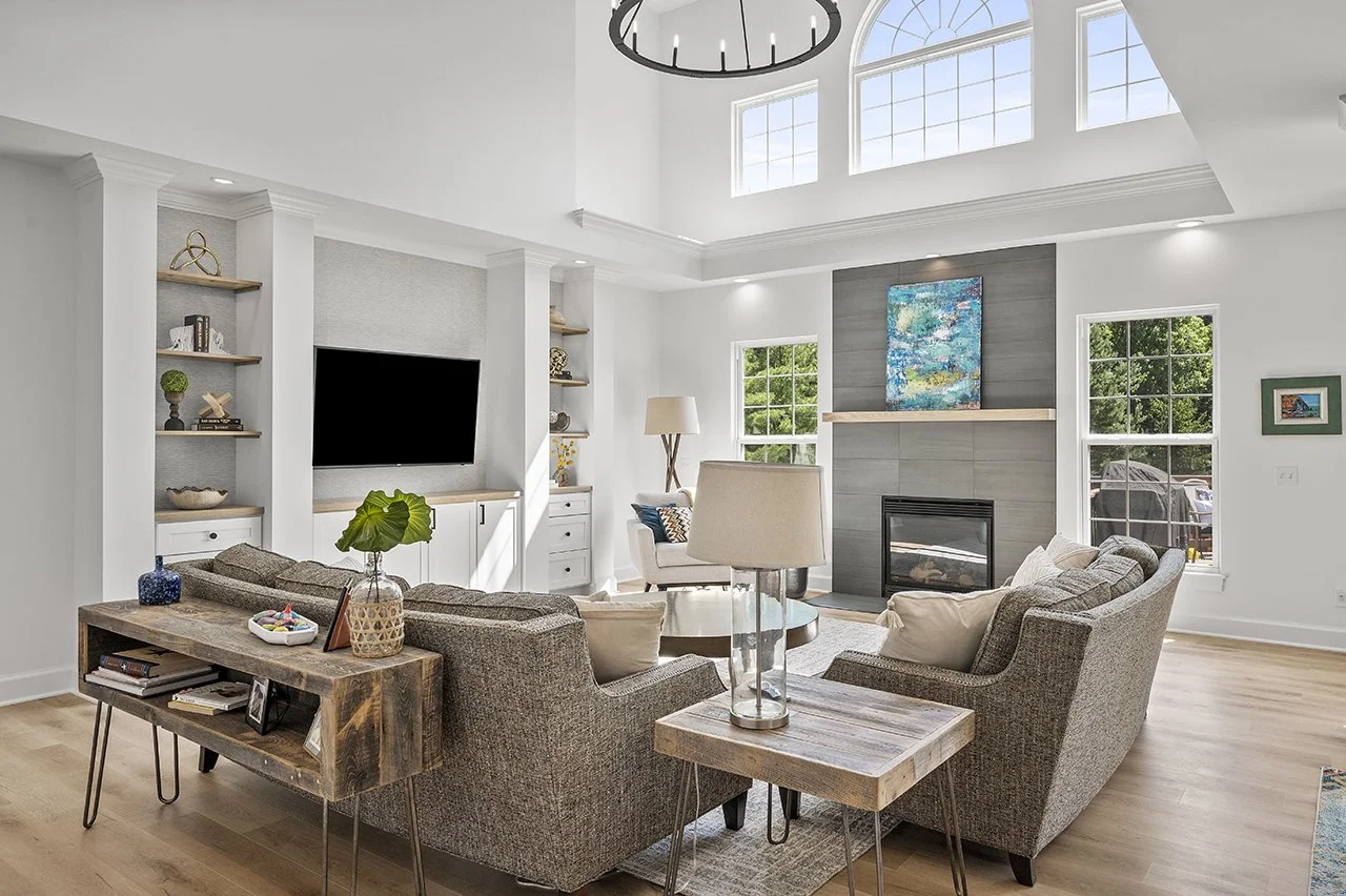Great room with a tiled fireplace surround and a wall with custom cabinetry and a wall mounted television.