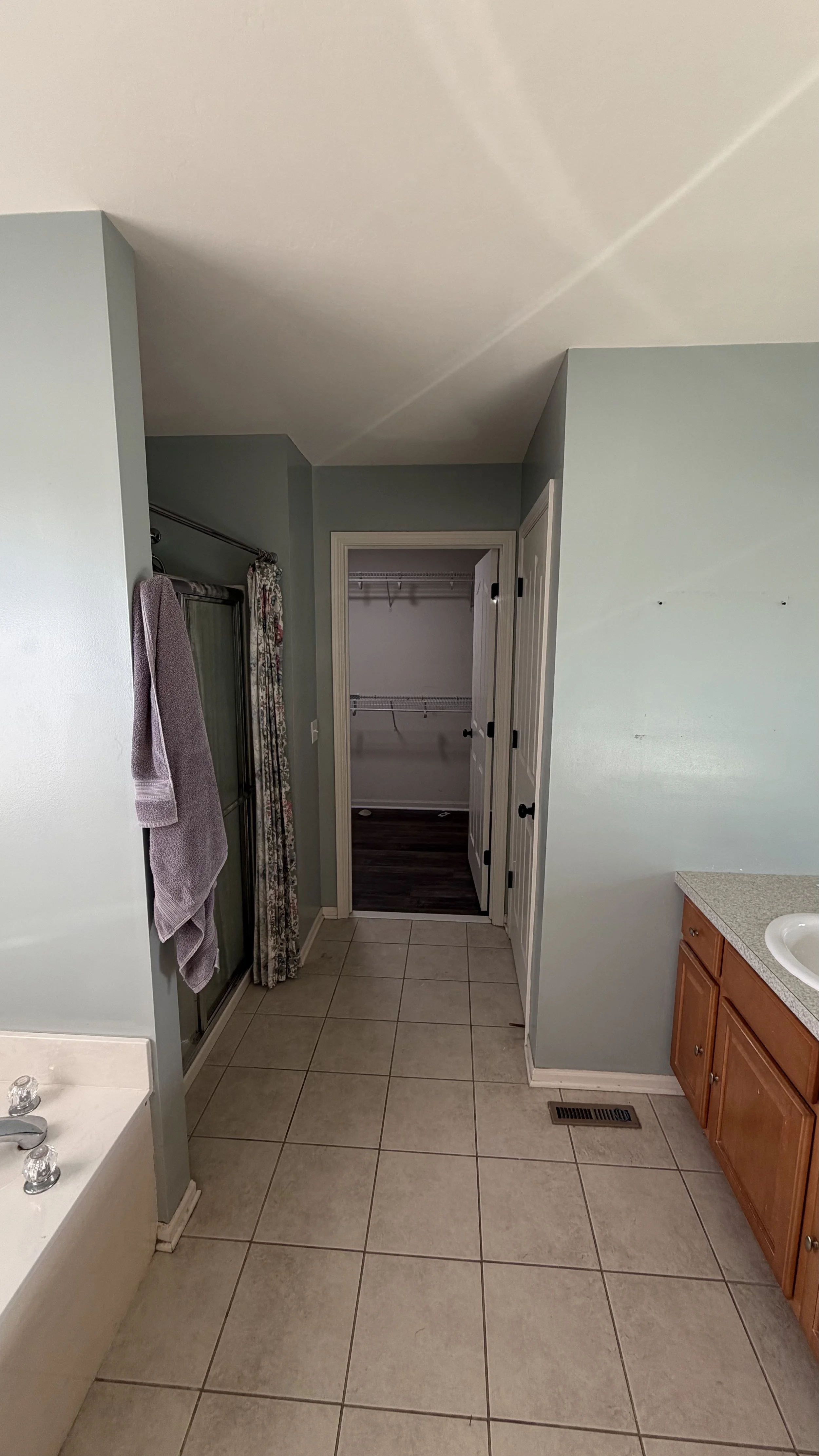 View of the master bathroom with a closet at the end that was converted into a laundry room