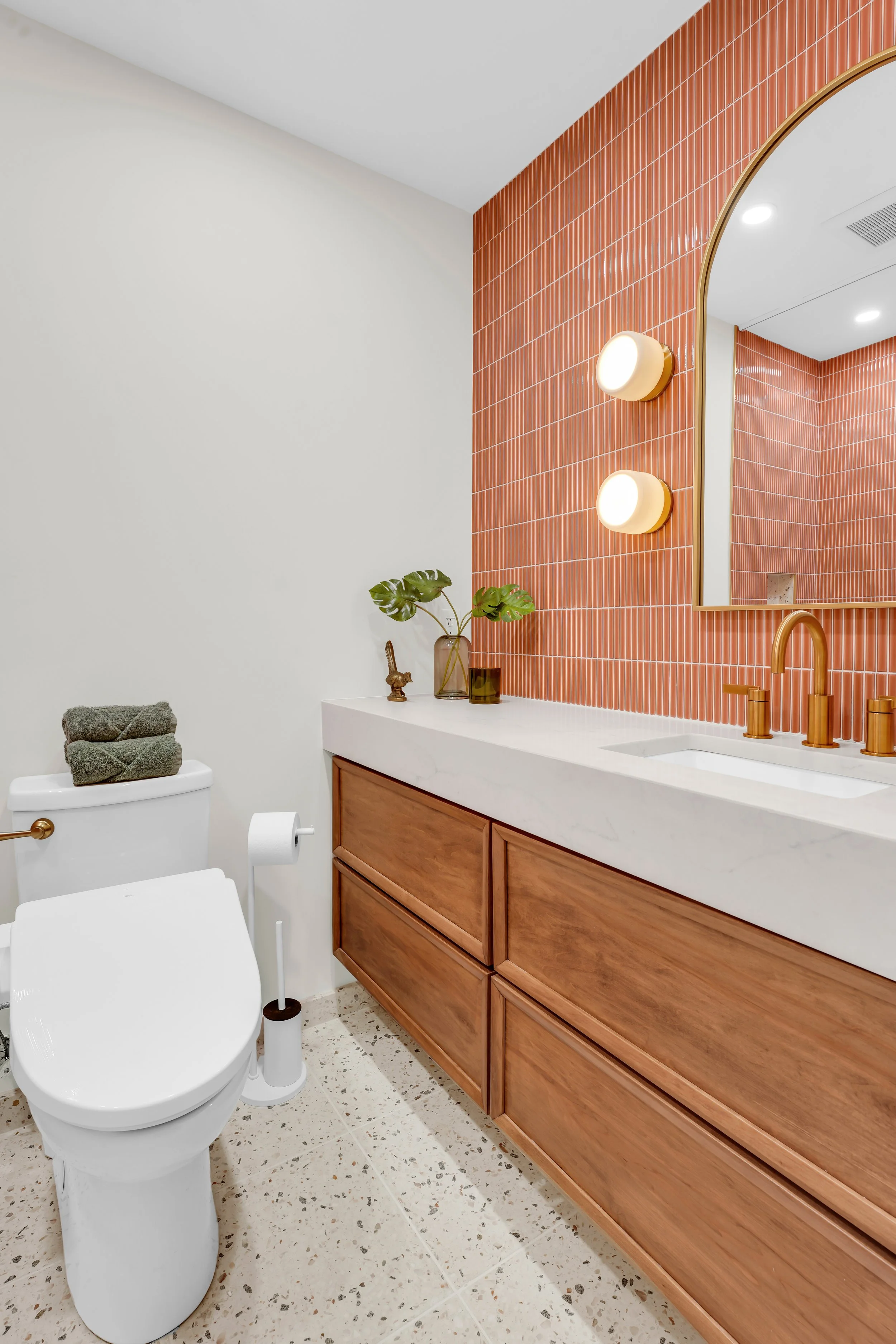 Wall to wall vanity with coral colored backsplash