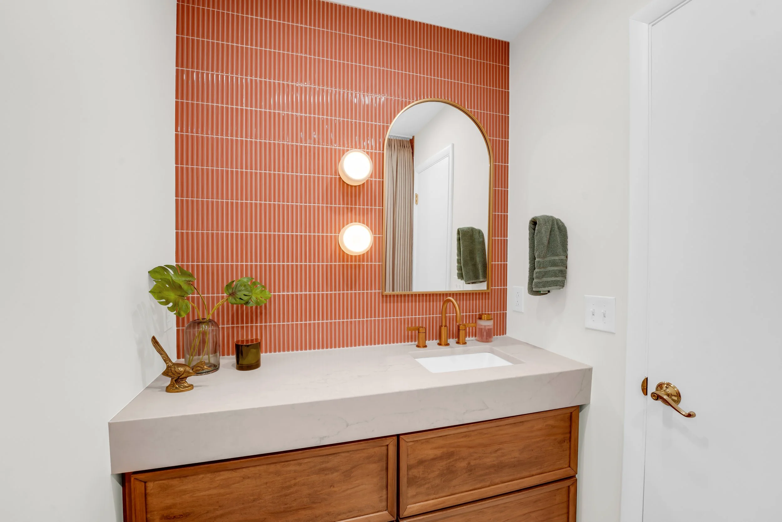 Wall to wall vanity with coral colored backsplash
