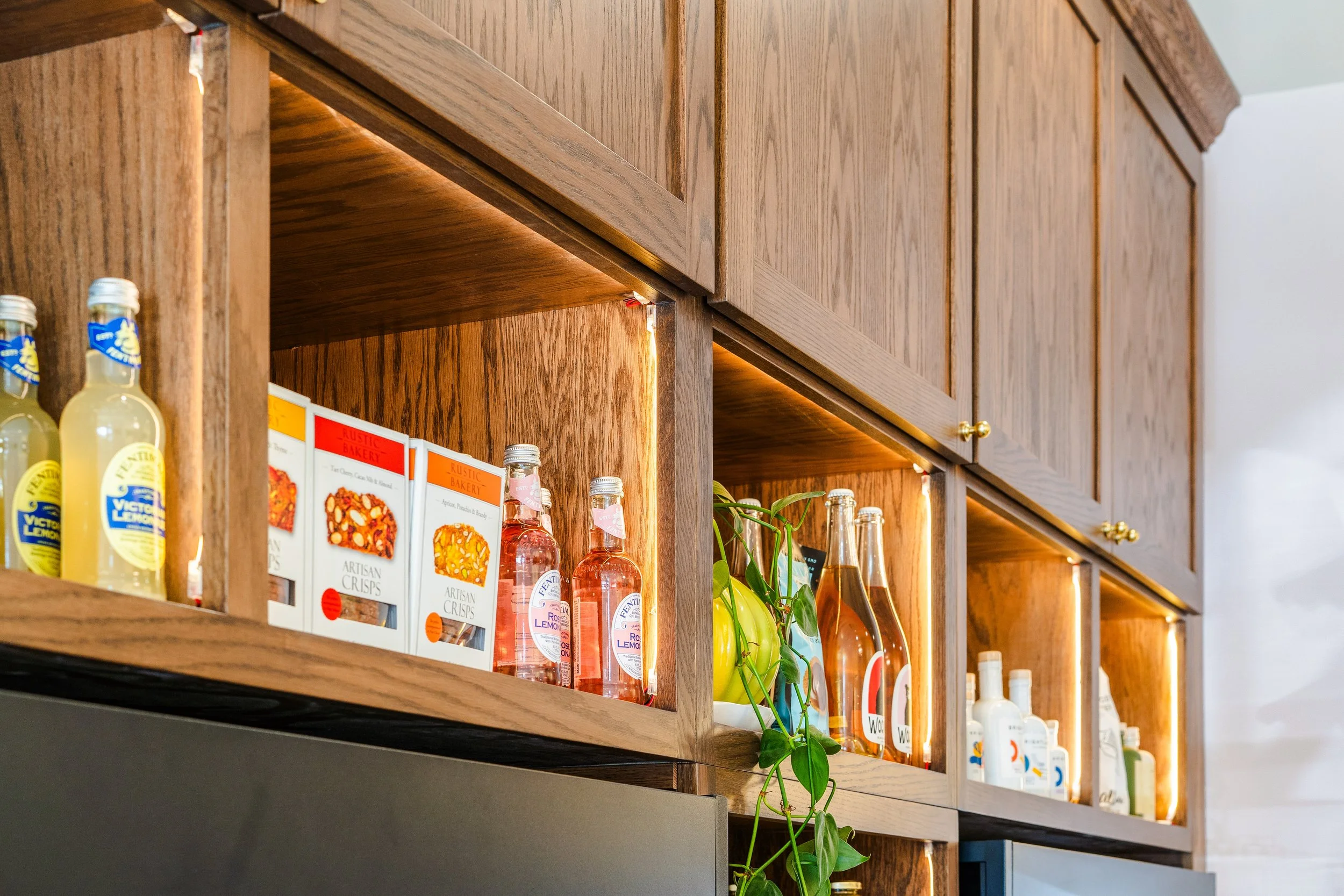 Open shelving in custom cabinetry along the grab and go wall.