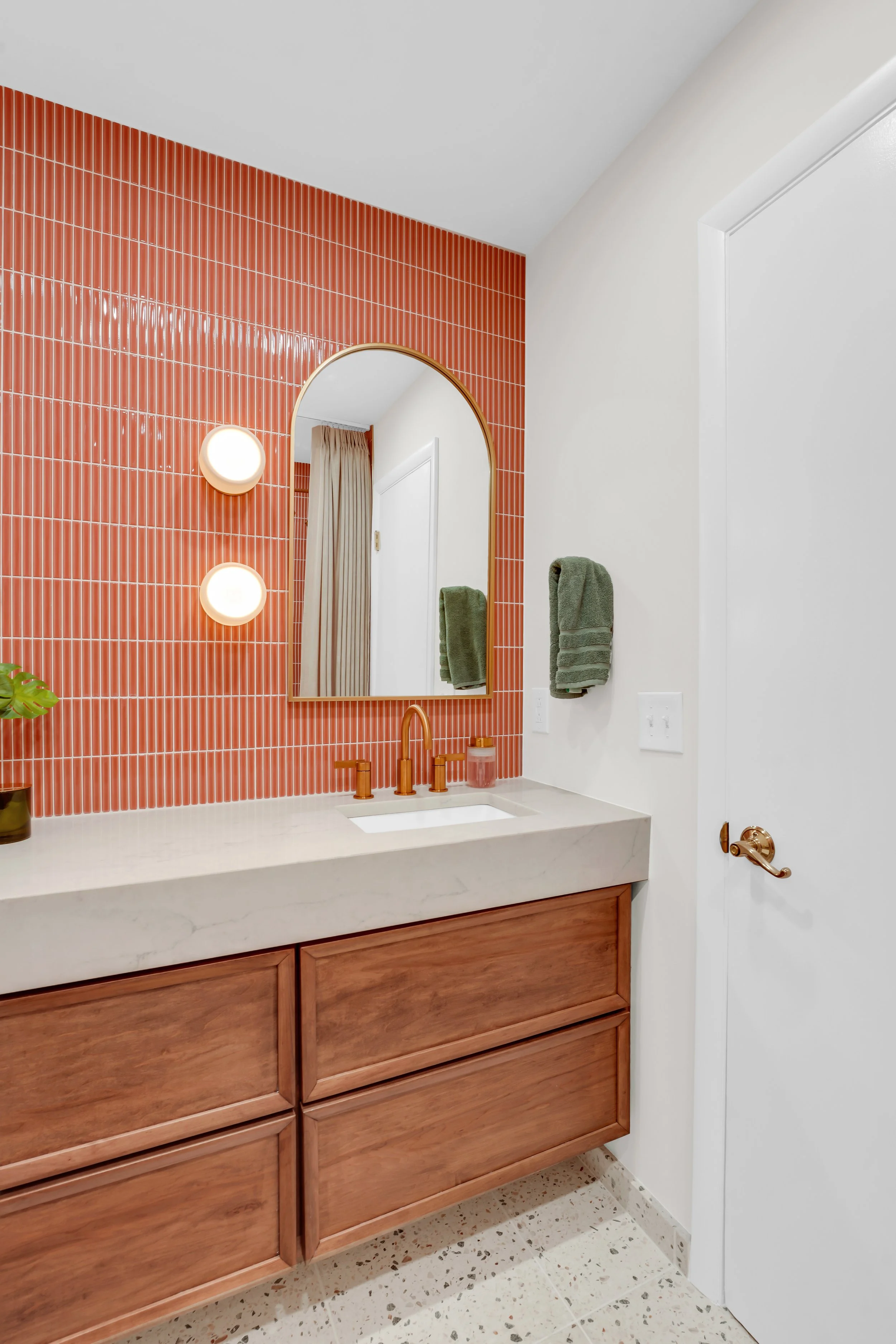 Wall to wall vanity with coral colored backsplash