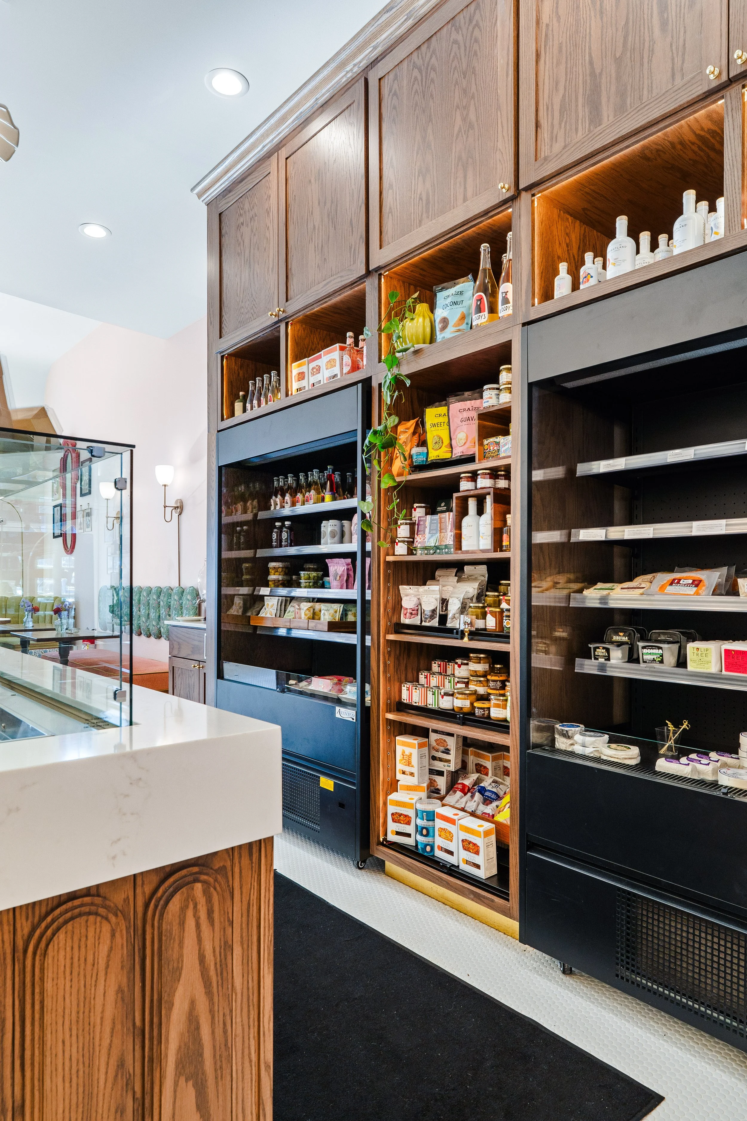 To-go refrigerated area along aisle in front of Constance's charcuterie assembly bar.