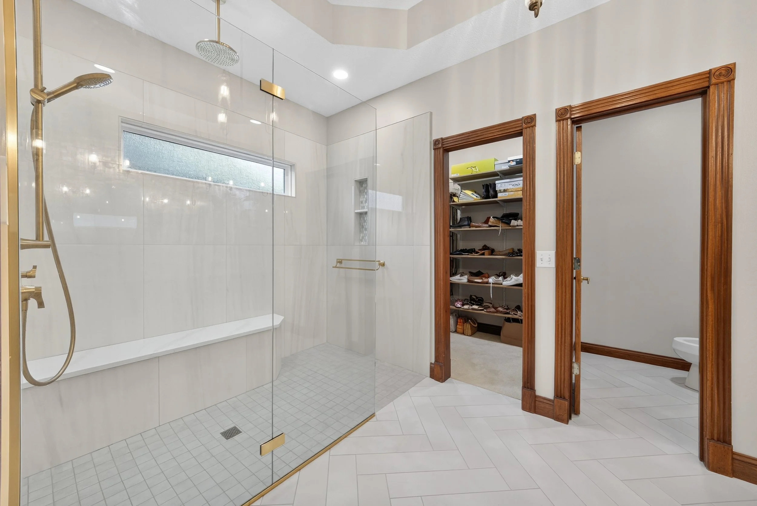 Curbless shower with natural tiling and gold accents.