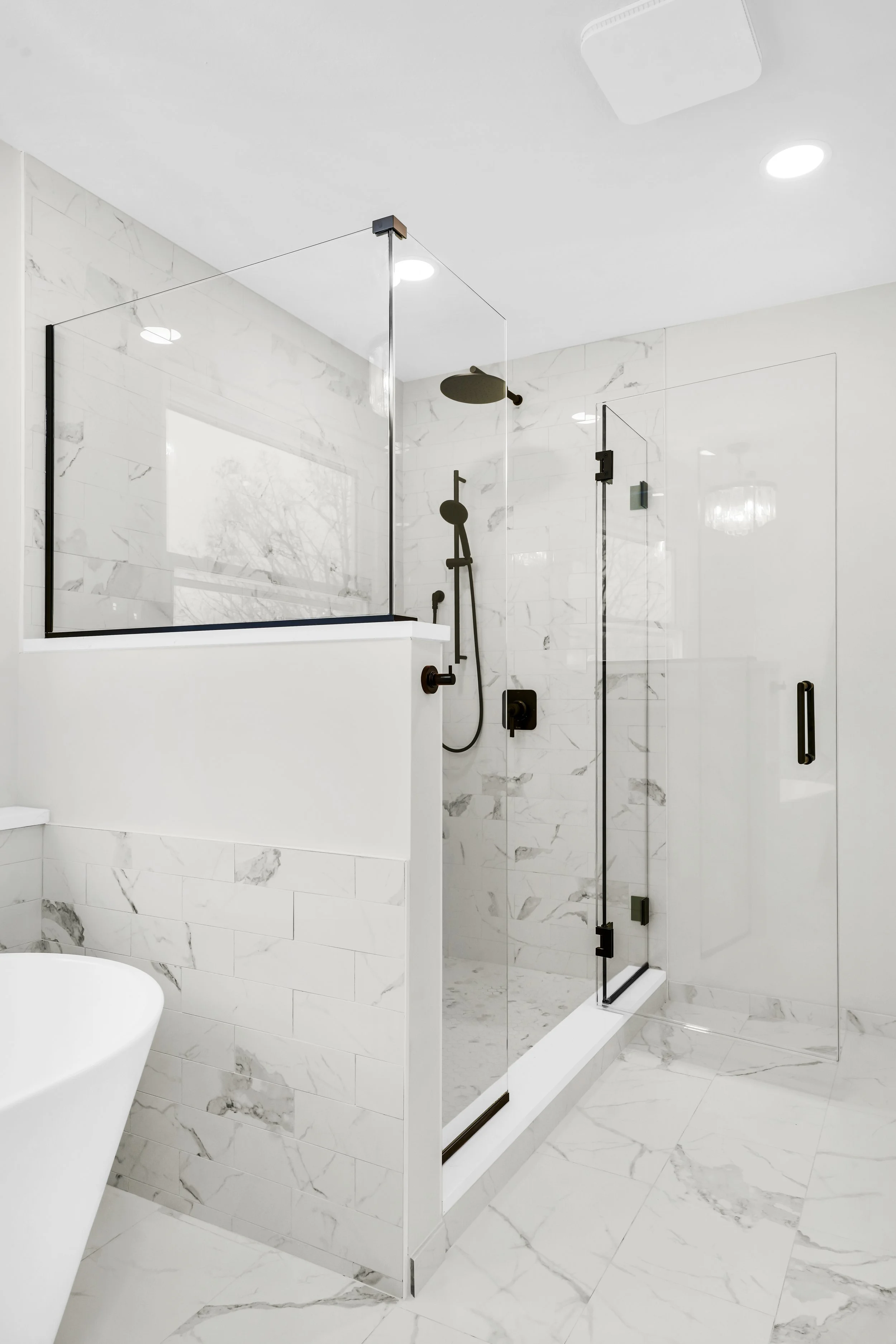 Shower and freestanding tub along the wall of a master suite