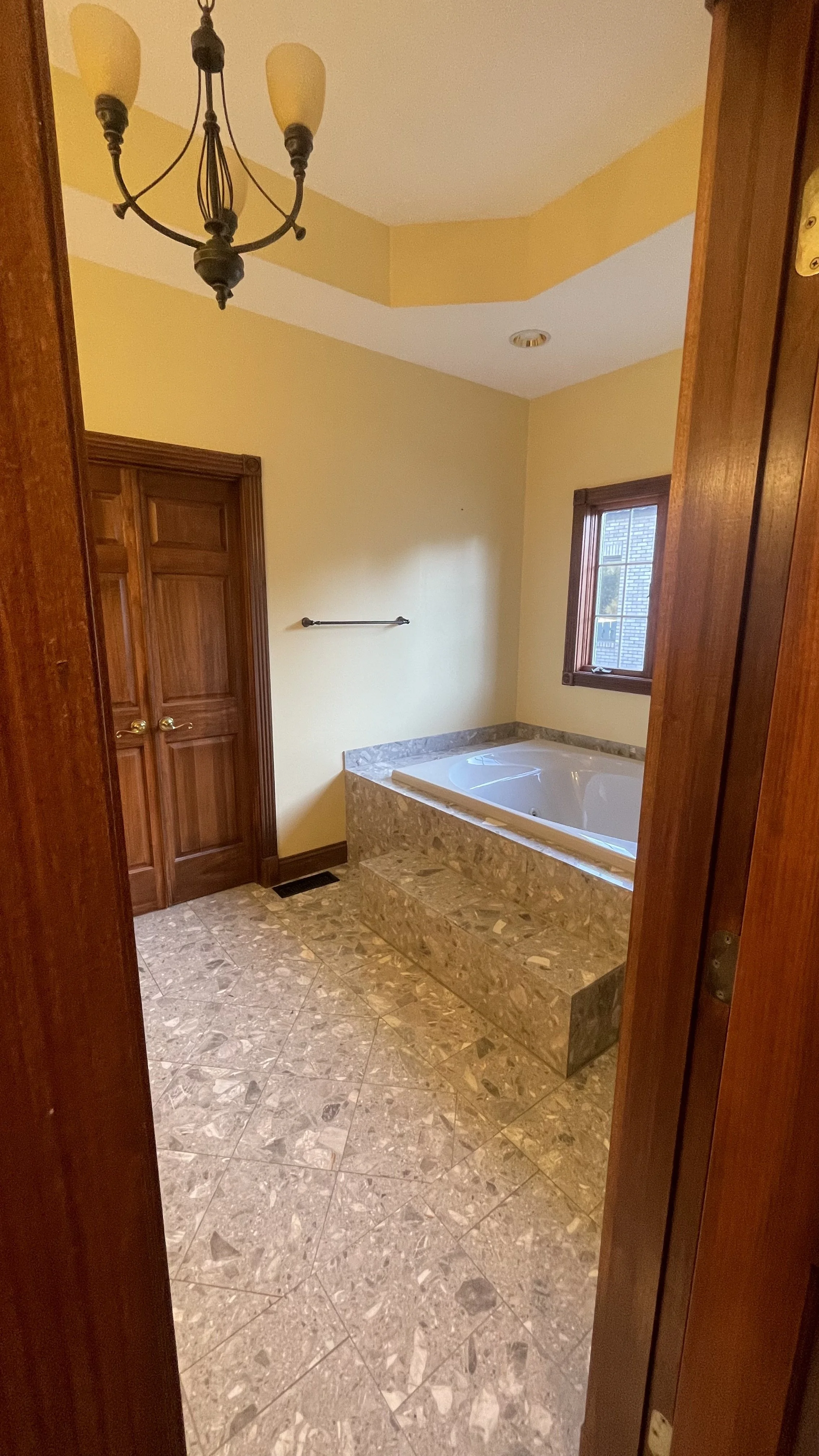 View from water closet looking towards drop in tub in master bathroom.