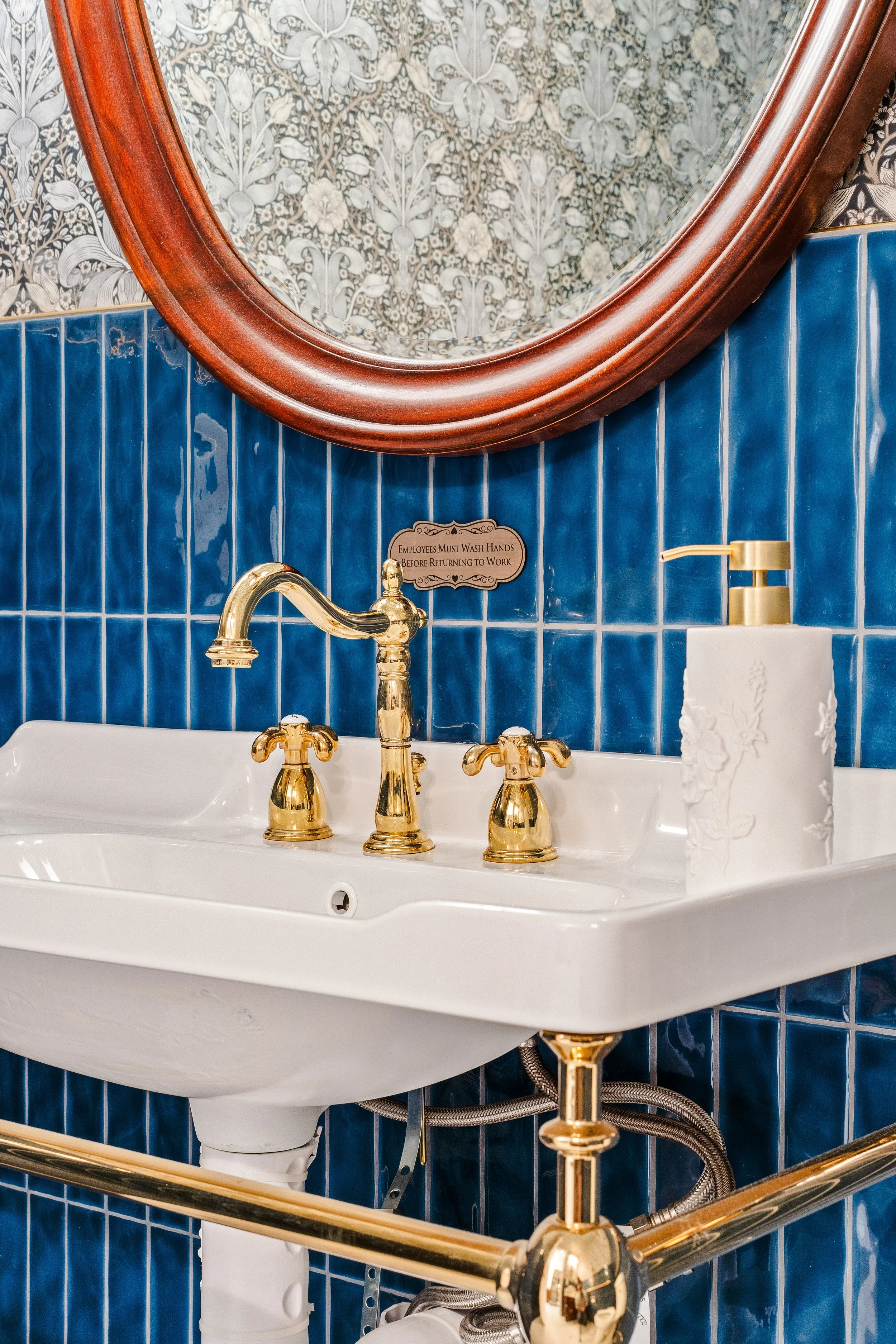 Dark blue bathroom wall tile with vintage inspired sink and good plumbing fixtures.