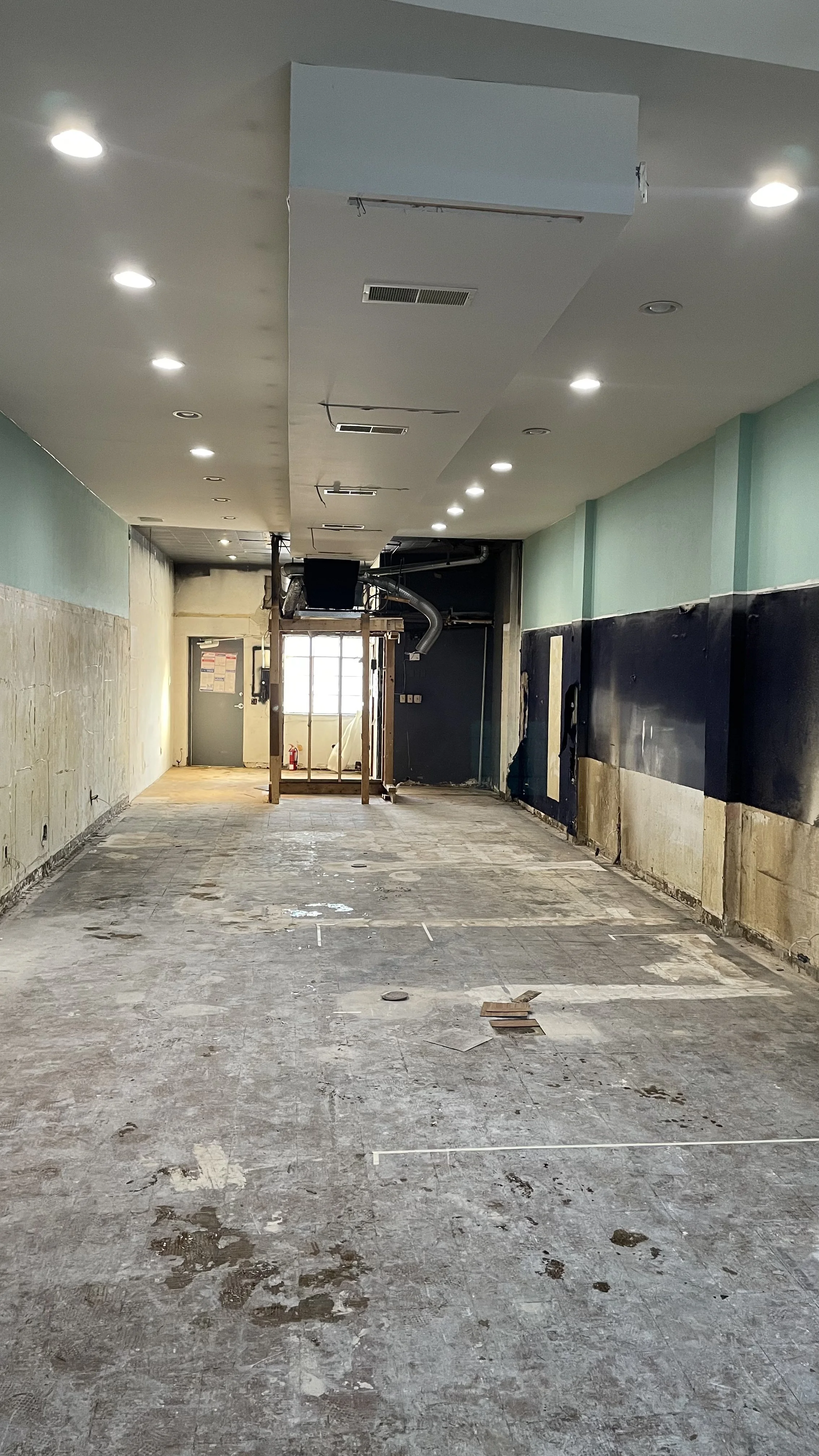 Mid construction of an empty retail storefront before renovation.