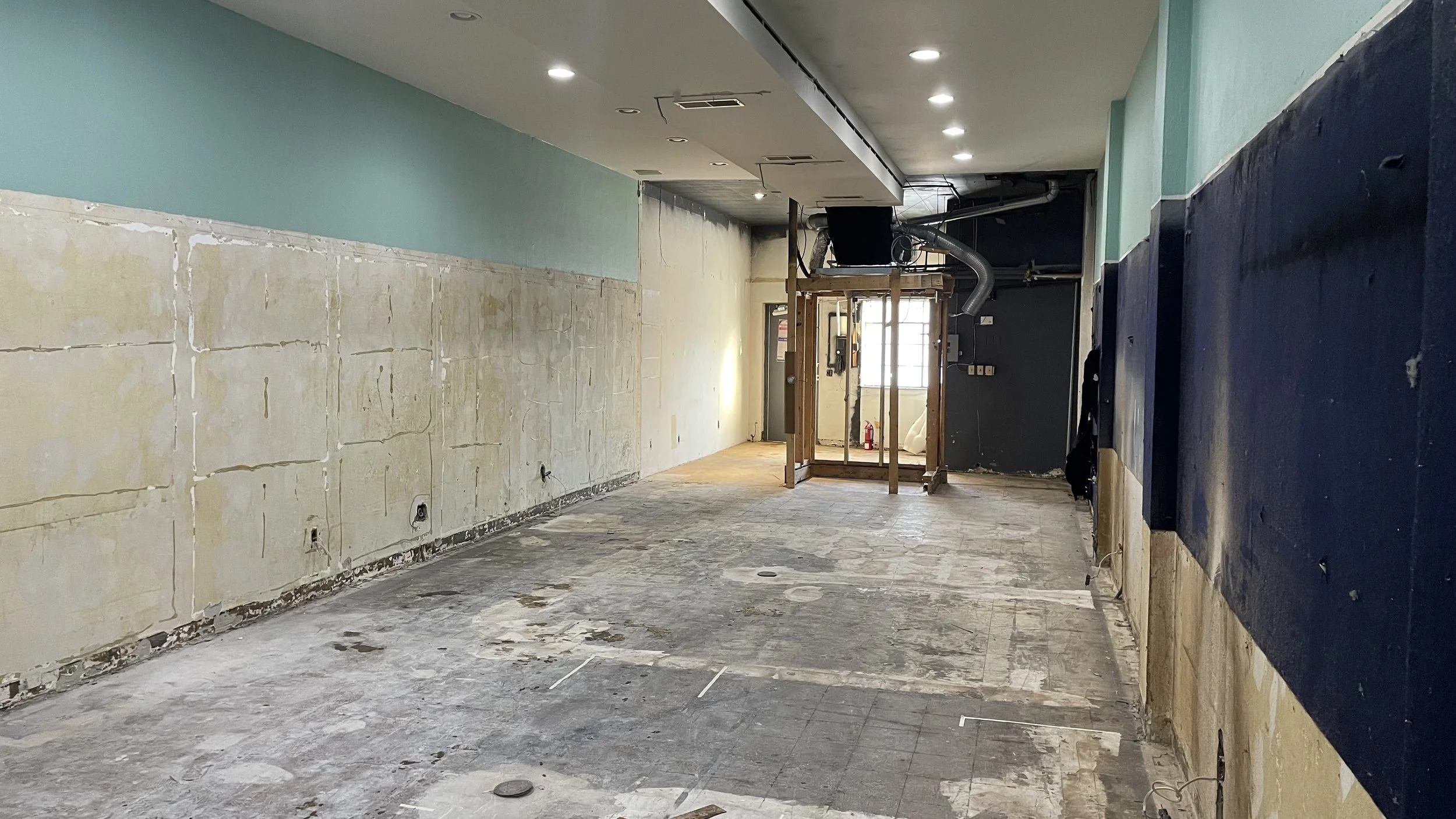 Mid construction of an empty retail storefront before renovation.