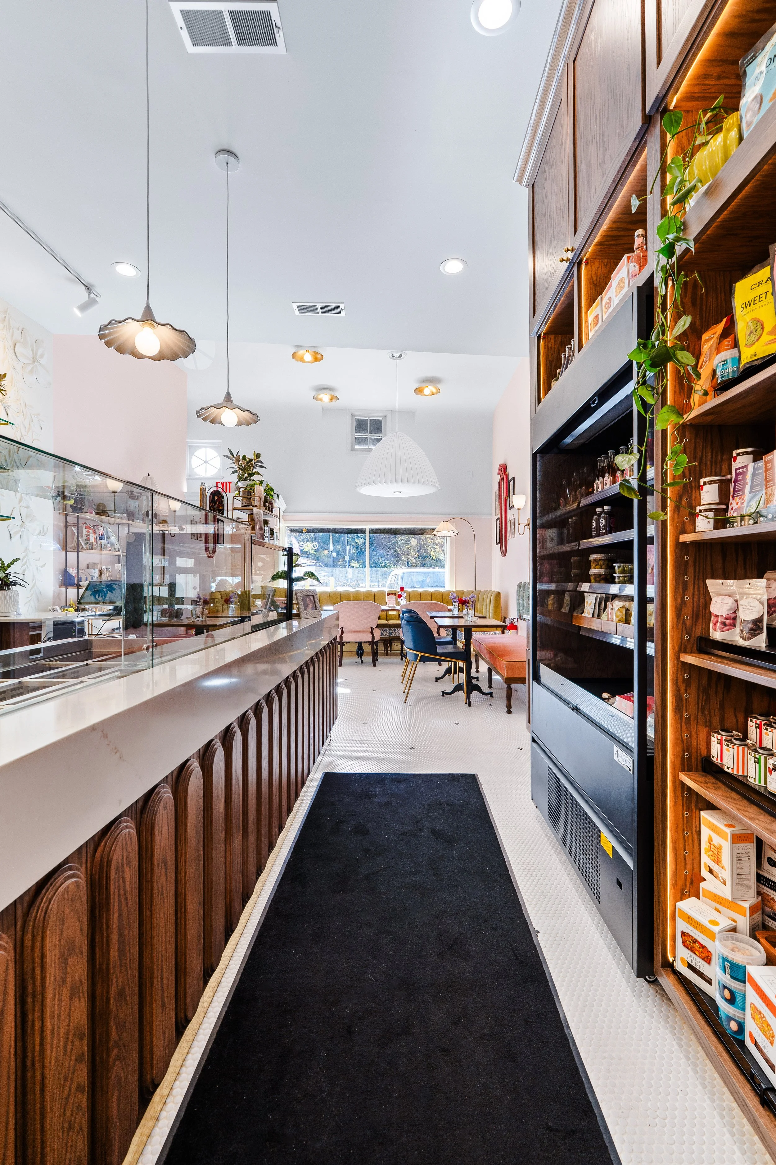 To-go refrigerated area along aisle in front of Constance's charcuterie assembly bar.