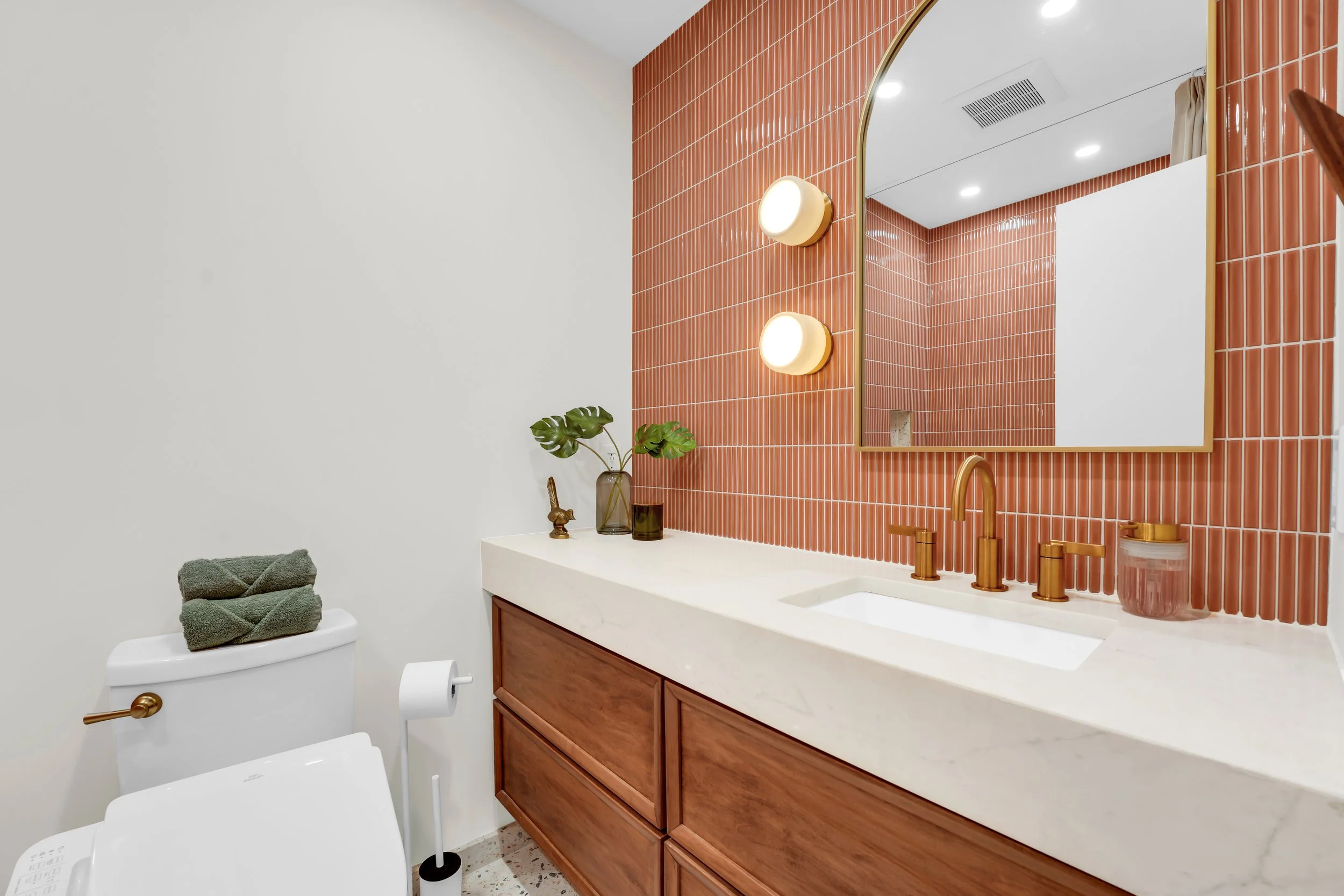 Wall to wall vanity with coral colored backsplash