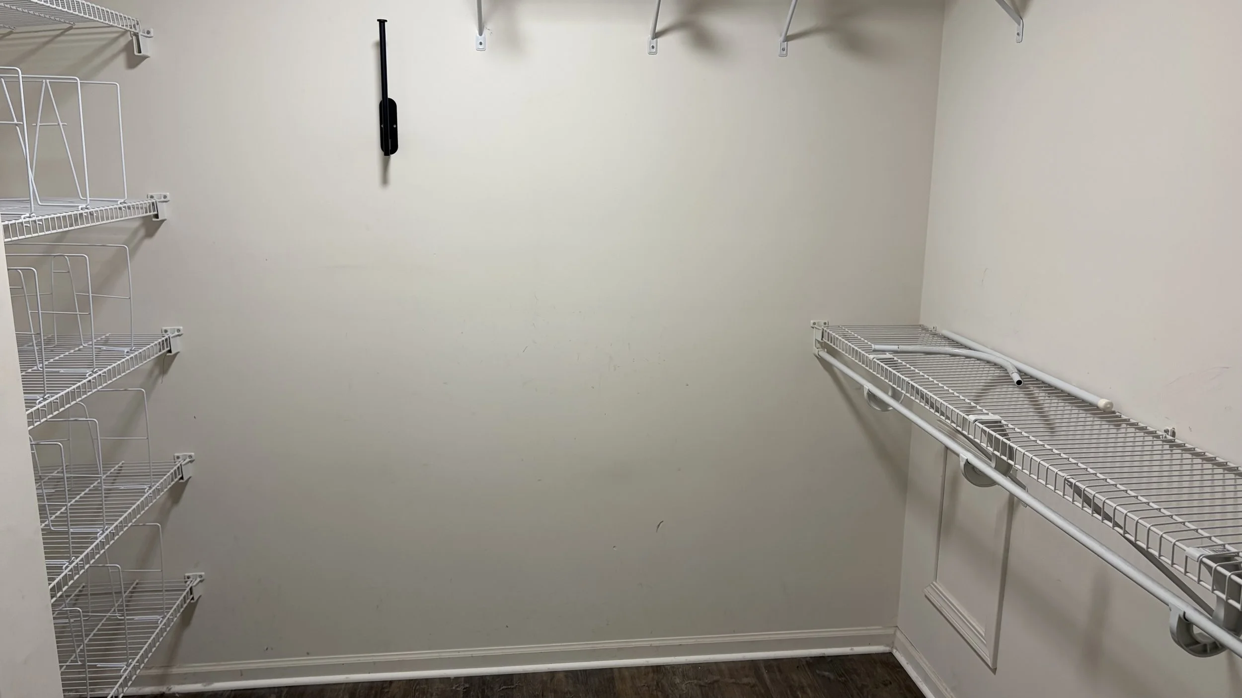 A closet with metal shelving that will later become a laundry room.