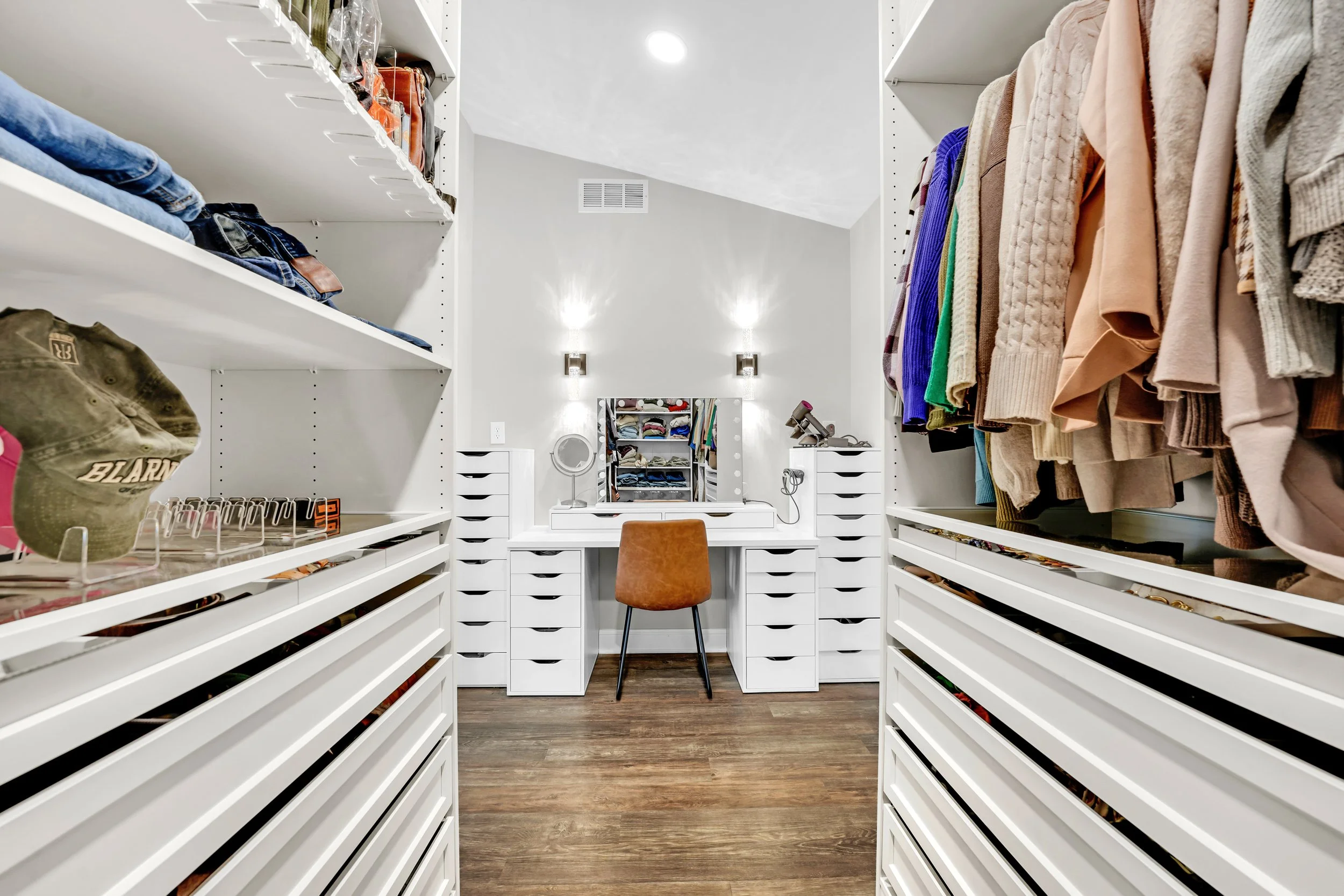 Walk in closet cabinetry with a makeup vanity along the far wall