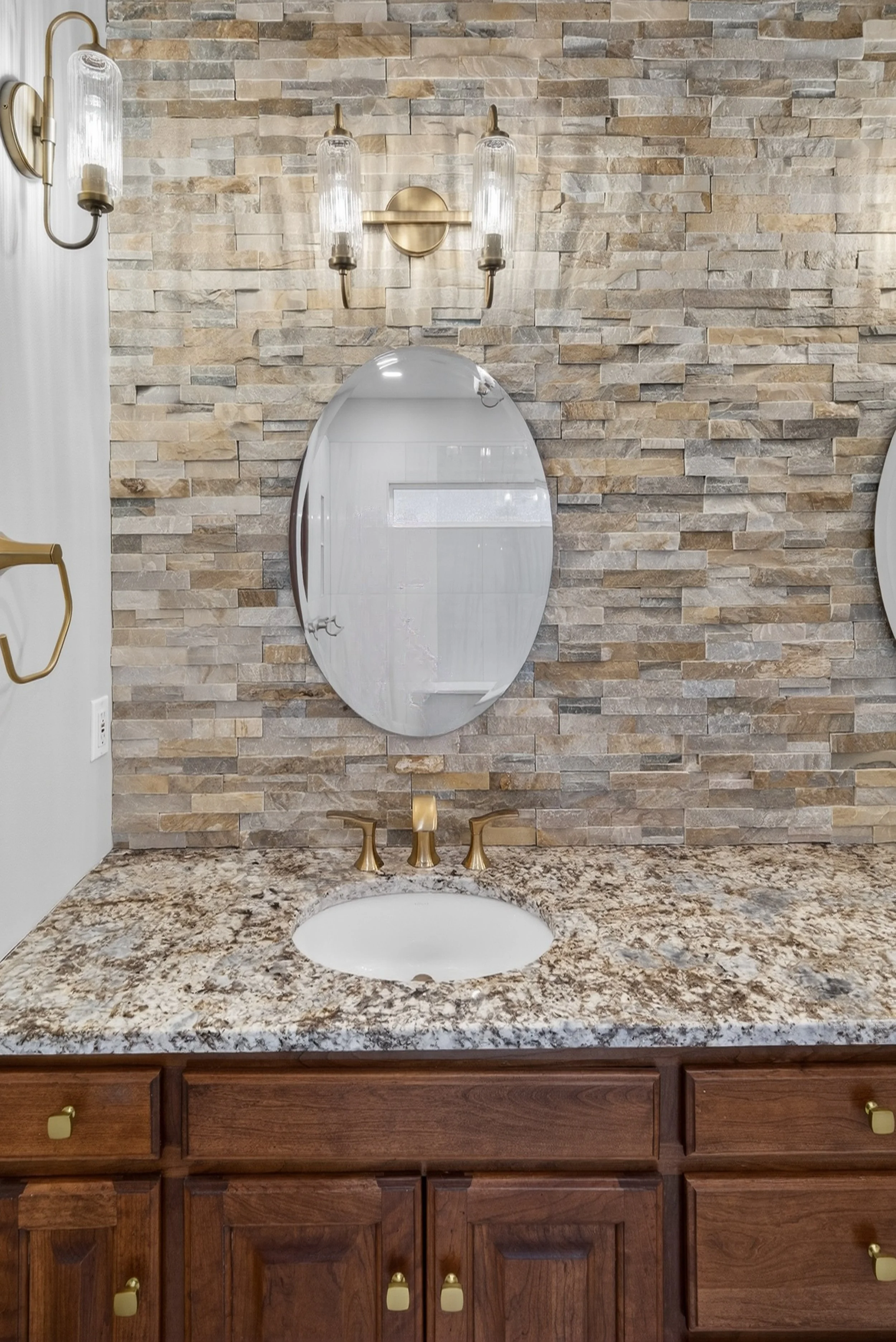 Oval shaped vanity mirror with a two light fluted glass vanity light above.