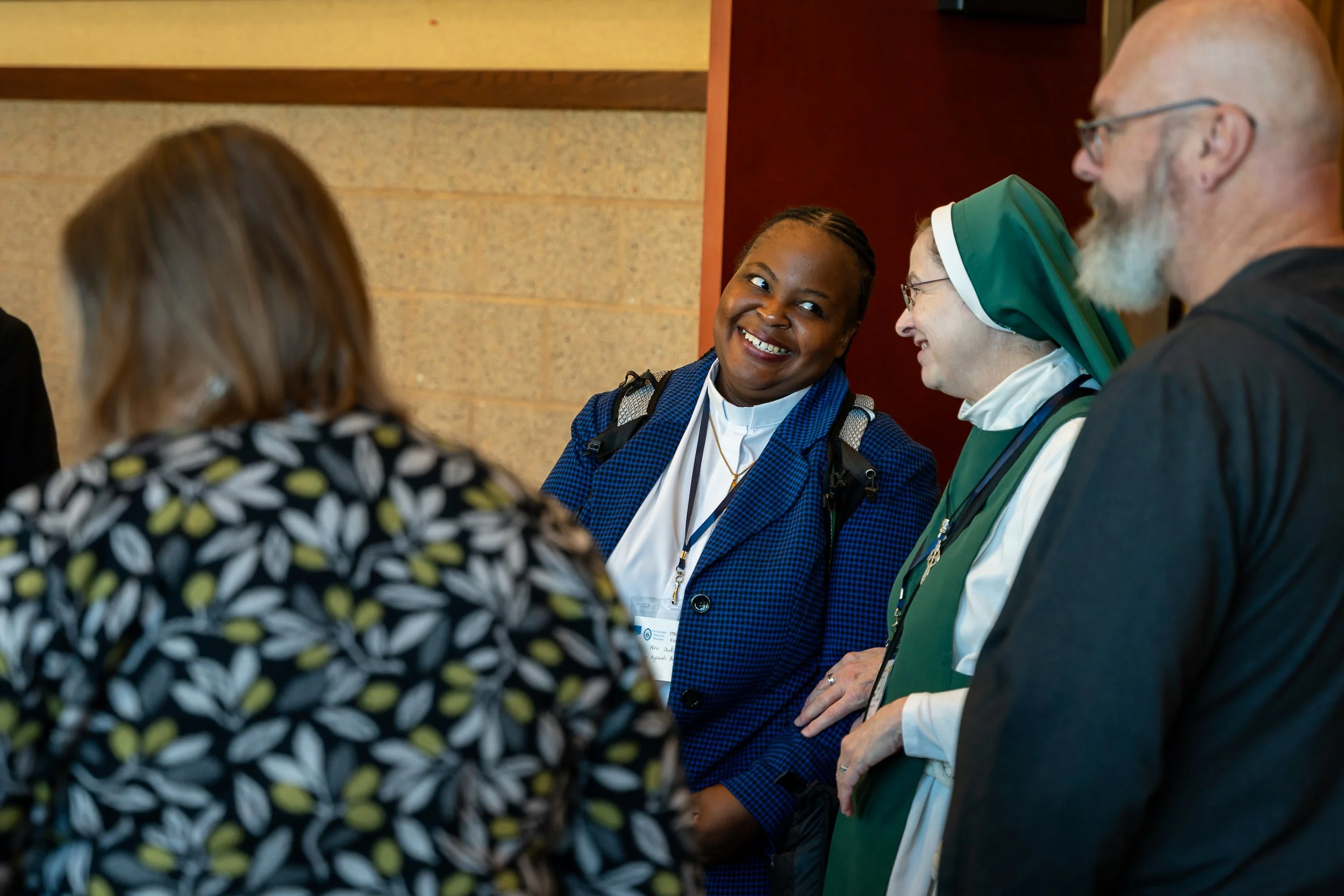 Two Clergy woman smiling at each other.