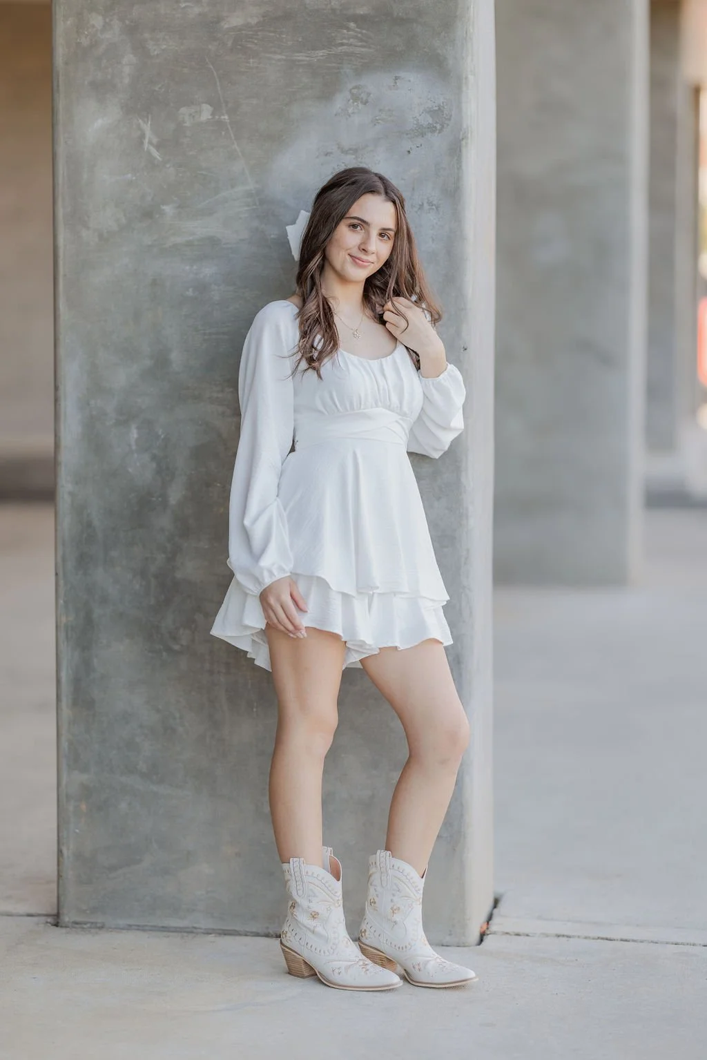 Portrait in a white outfit against a textured wall