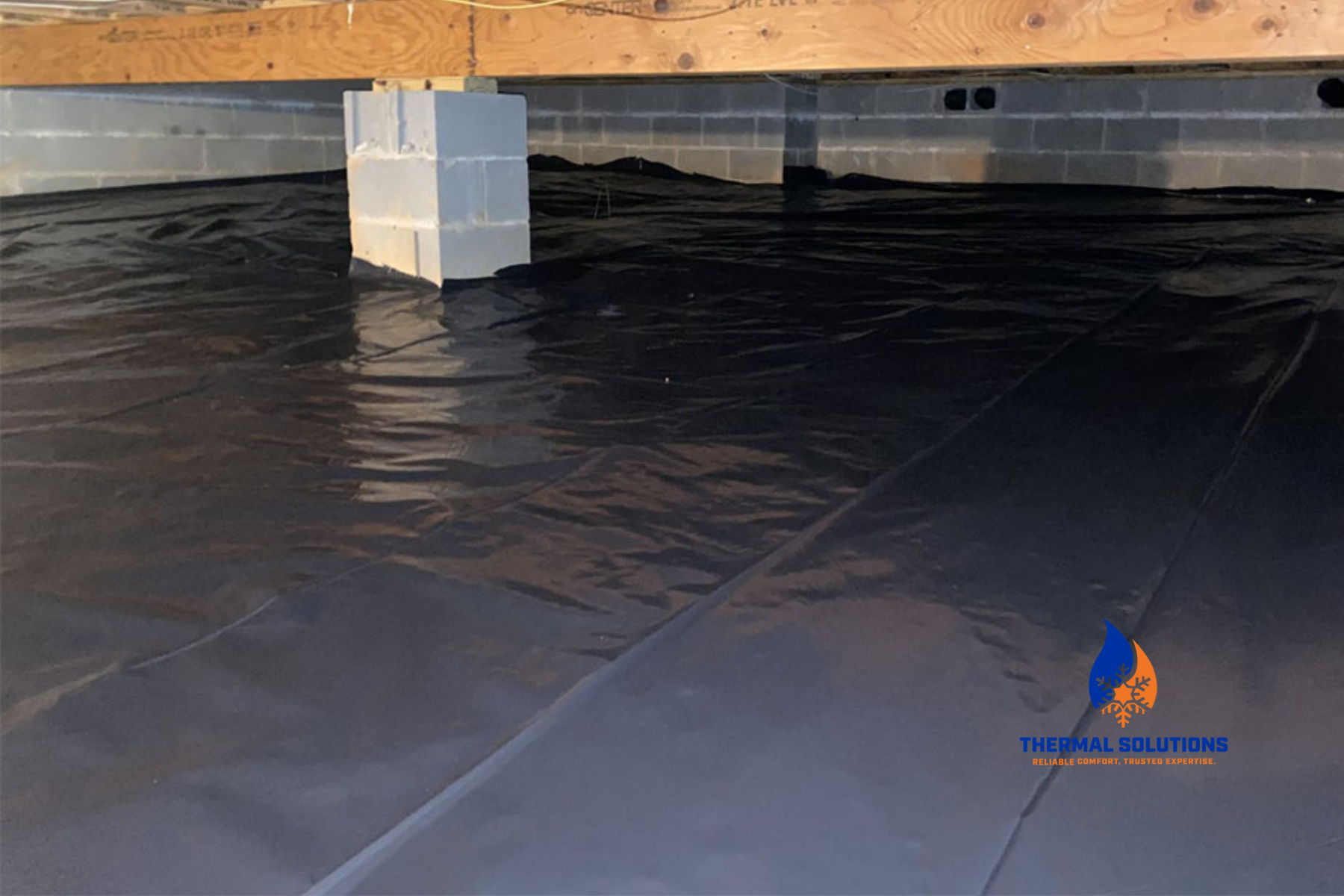 A crawl space vapor barrier, covered by black waterproofing membrane on the floor. The logo for Thermal Solutions is in the bottom right corner.