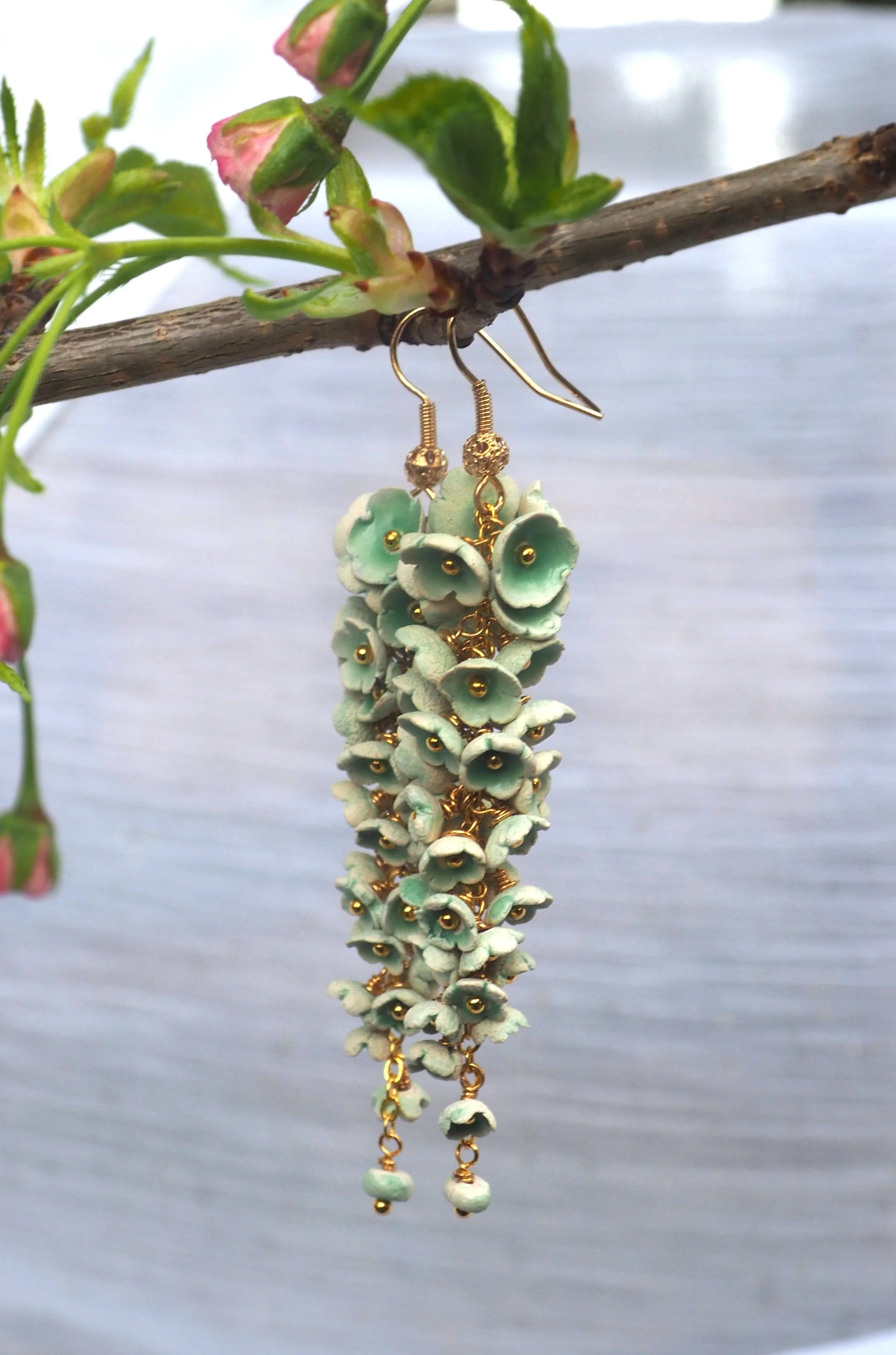 Floral cascade of ceramic flowers with jade glaze pooling in the center, reminiscent of wisteria blossoms
