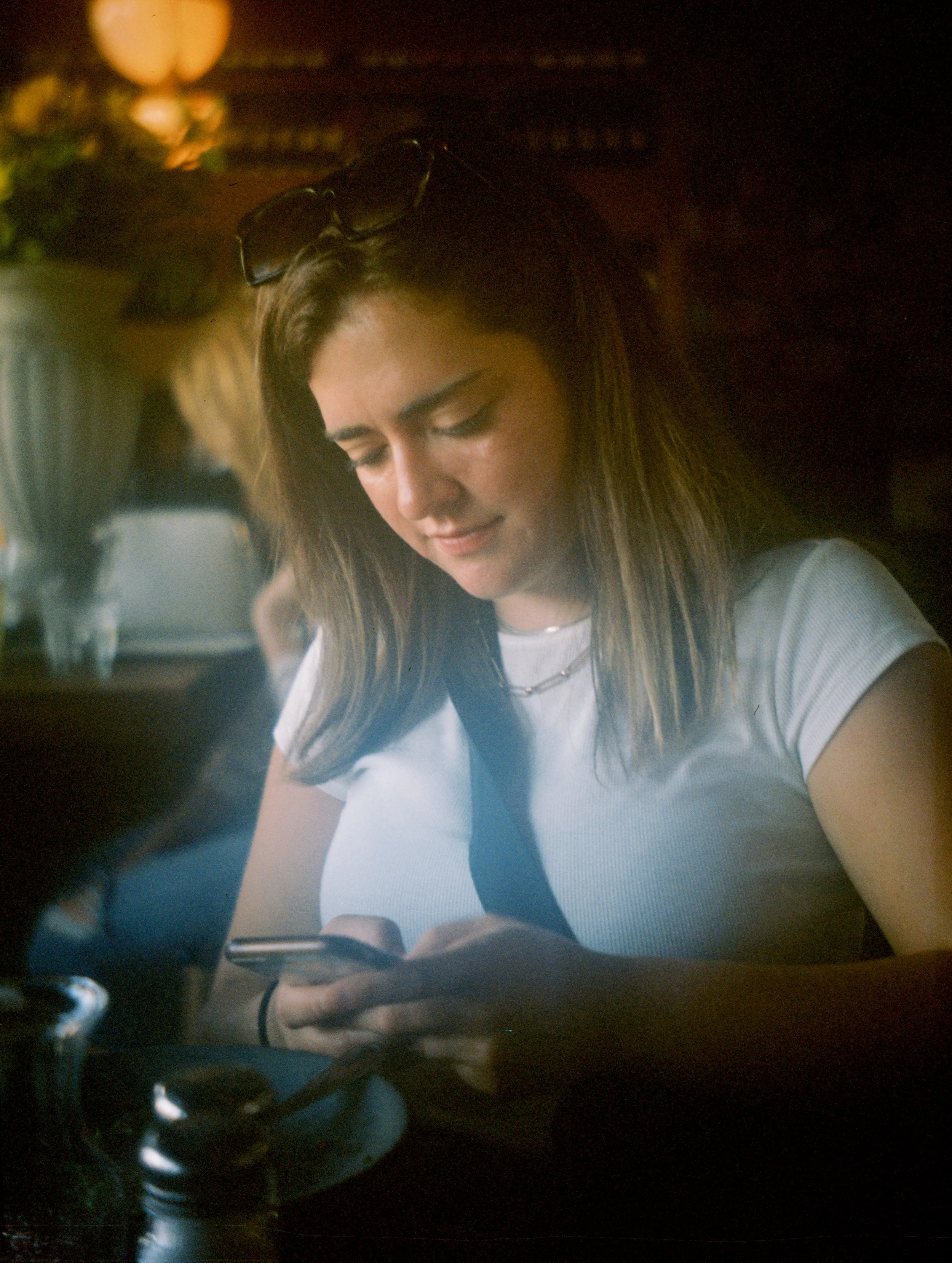 A woman sits looking at her phone