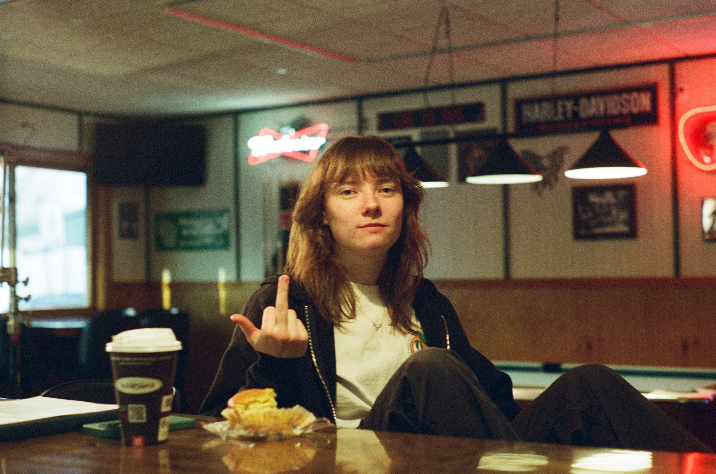 A woman flips off the camera