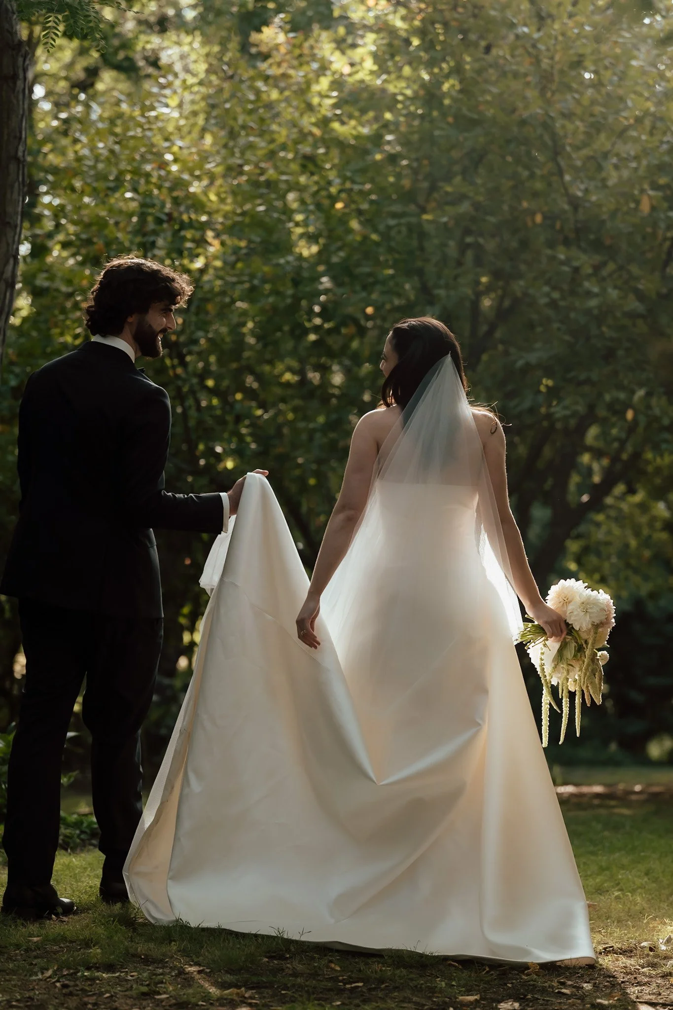 Braidwood Wedding Photographer. A bride and groom holding hands outdoors with trees in the background.