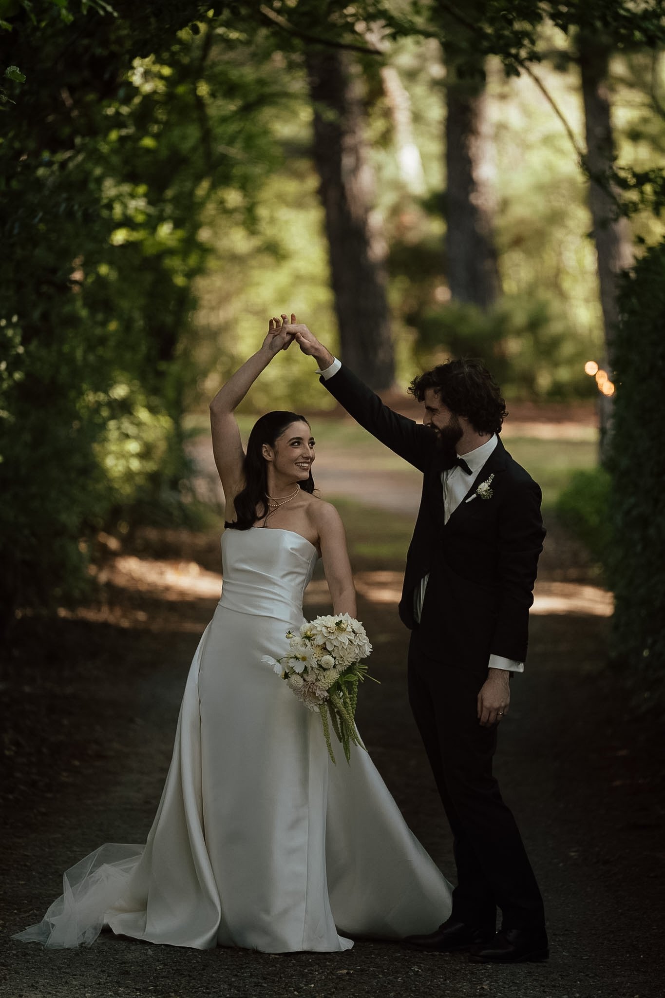 Braidwood Wedding Photographer. A bride and groom dancing outdoors on a wooded path in a wedding photo.