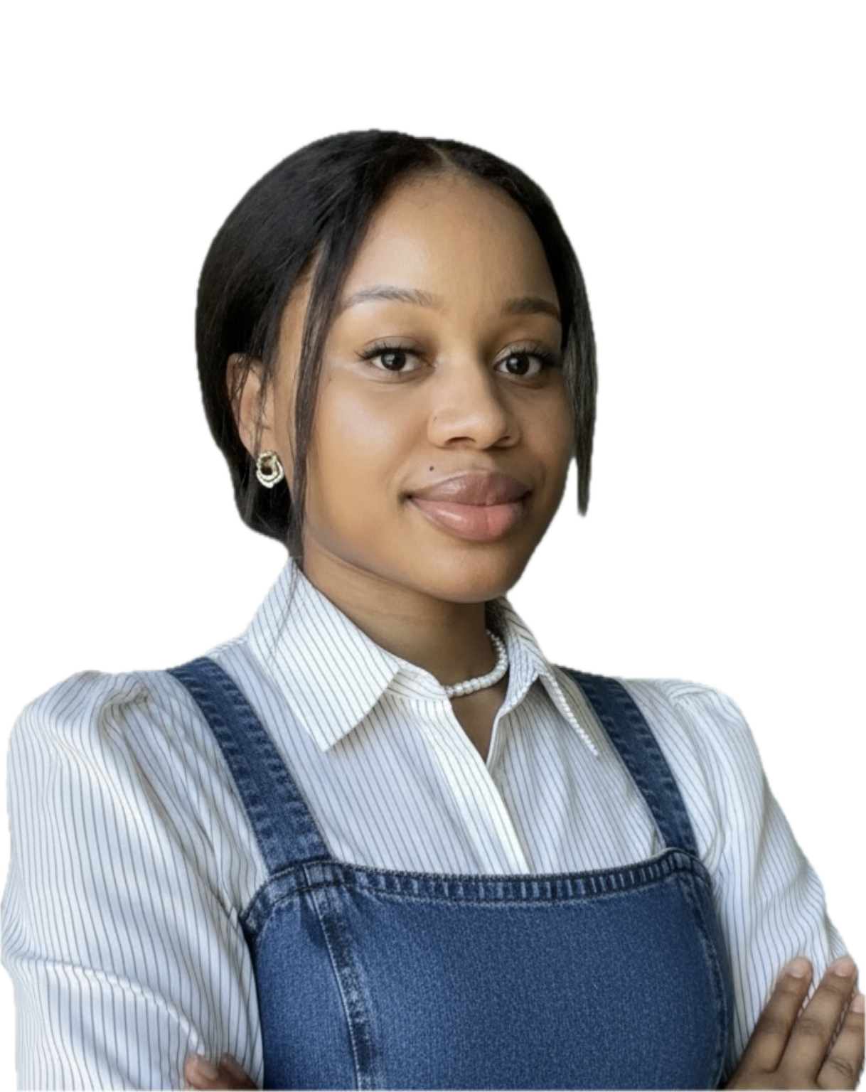A woman with short black hair, wearing a white striped shirt and denim overalls, standing with her arms crossed and smiling slightly.