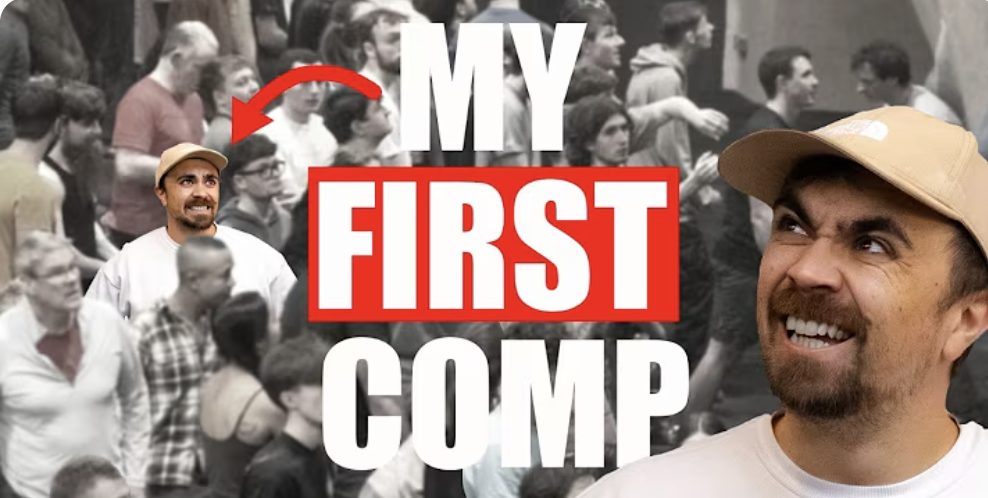 A man with a beard and a beige cap smiling, with a crowd of people in the background and the bold text 'MY FIRST COMP' overlaying the image.