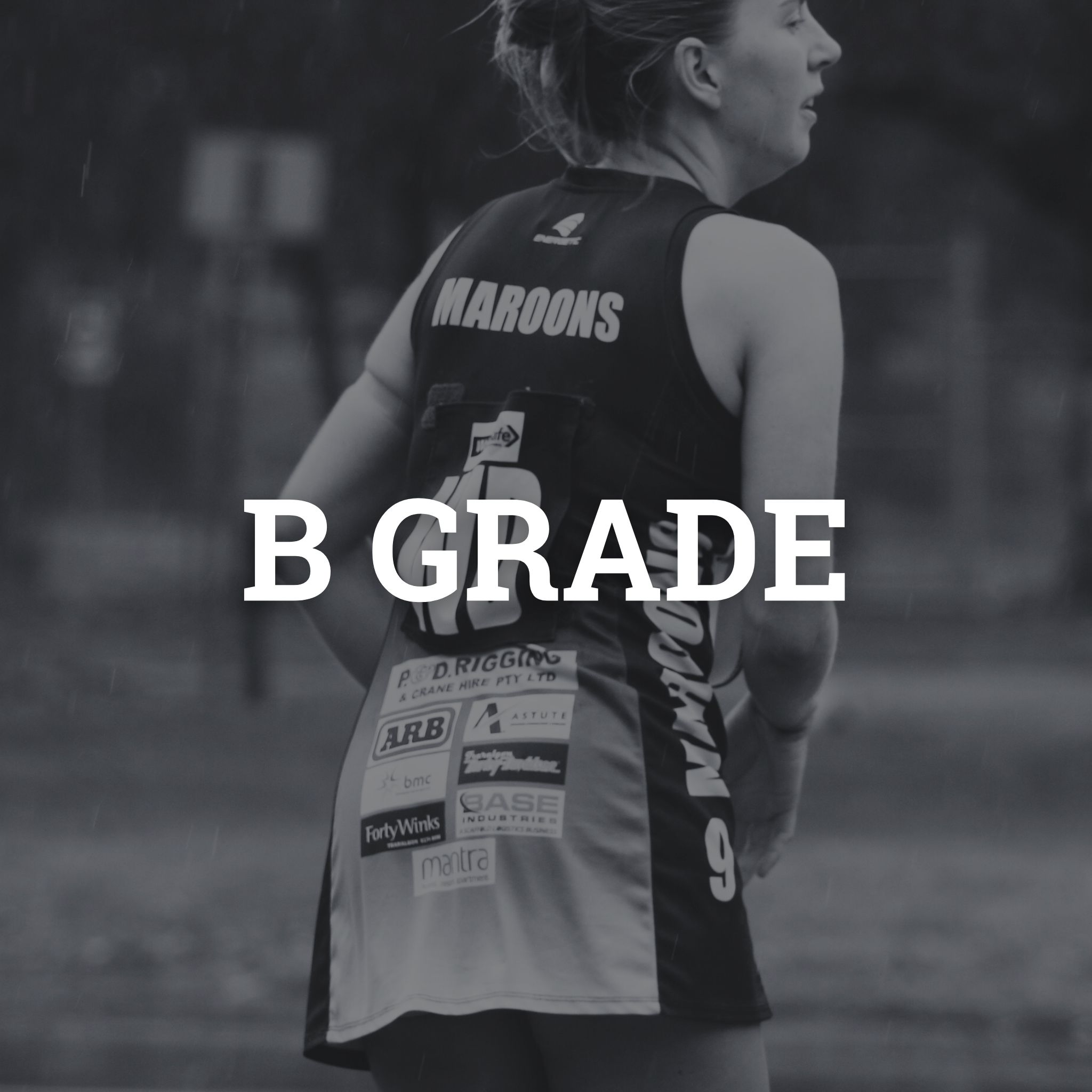 A woman in sports attire with the word "MAROONS" on her back standing outdoors in the rain, with sponsorship logos on her shorts and a digital device attached to her back.