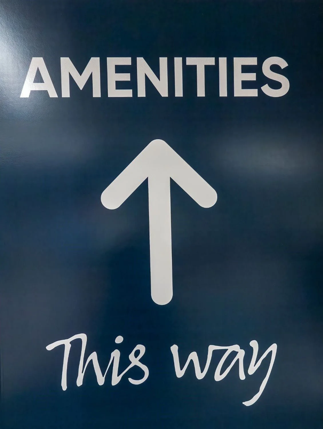 A sign that reads, "Amenities This Way" with an arrow pointing up.