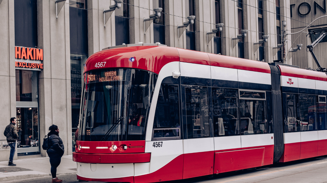 Toronto TTC streetcar picking up a woman at a public transit stop