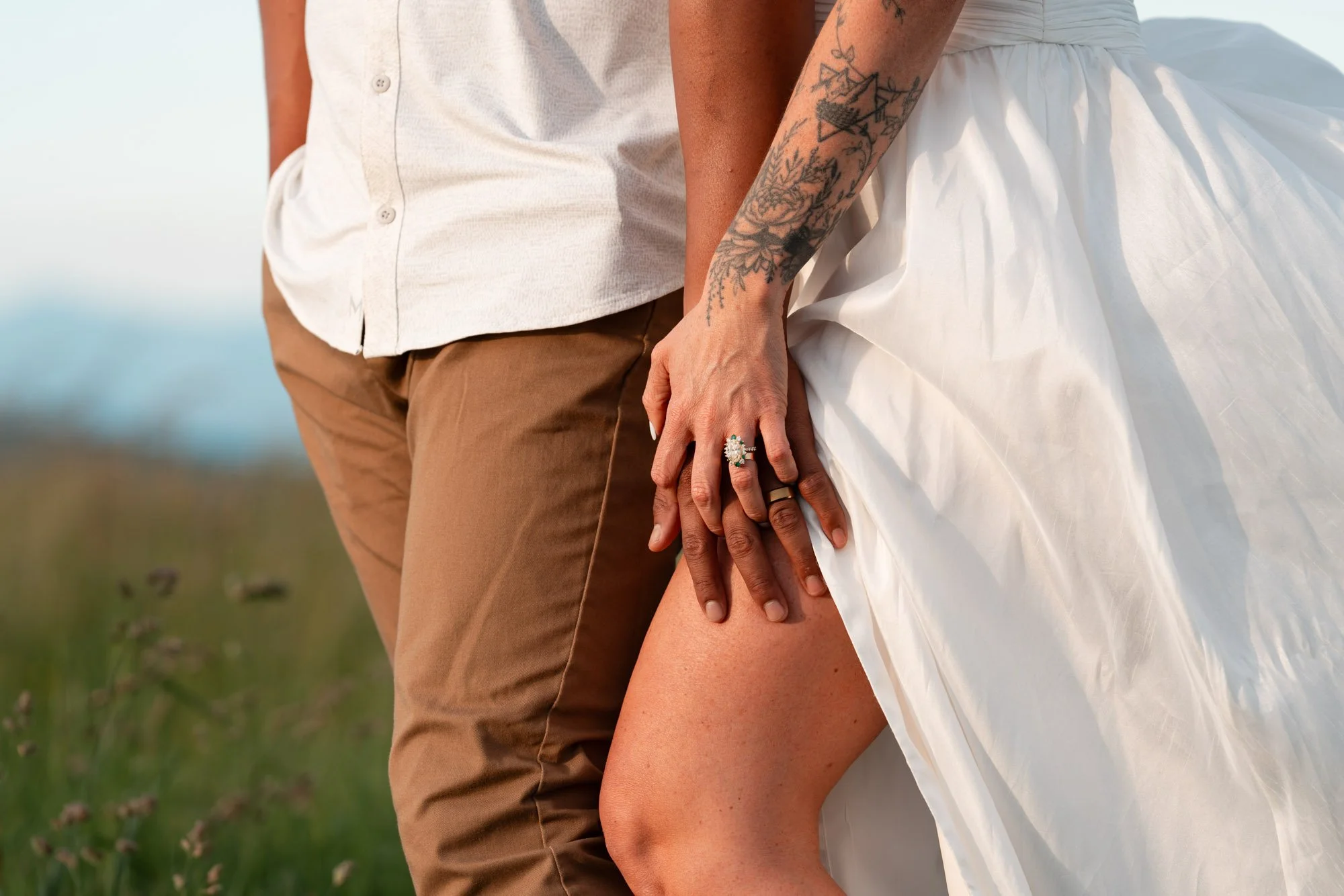 Couple holding hands with wedding rings at Max Patch near Asheville, North Carolina