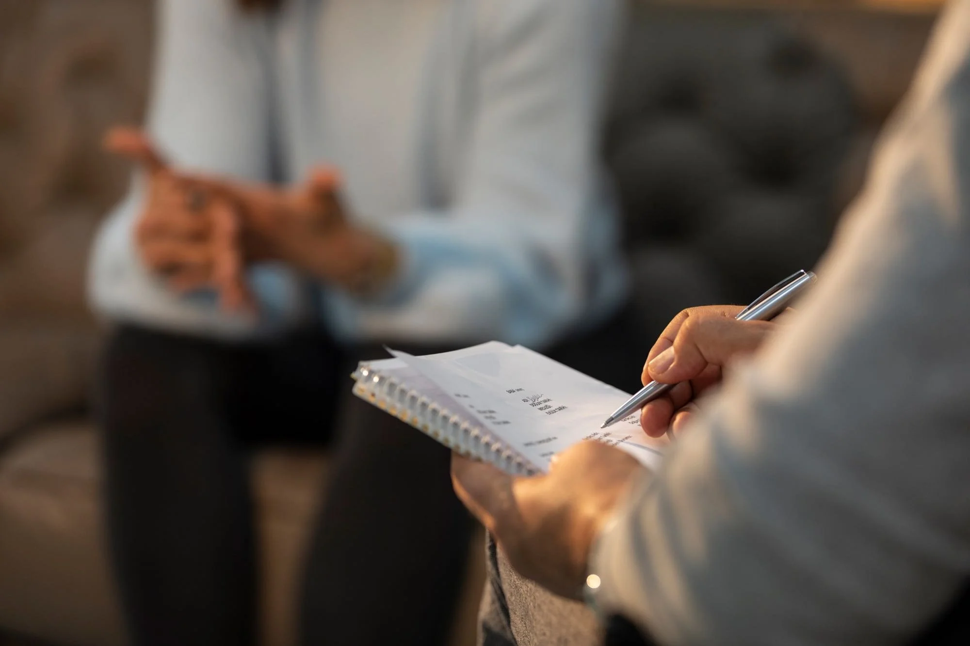Person taking notes during a business meeting.