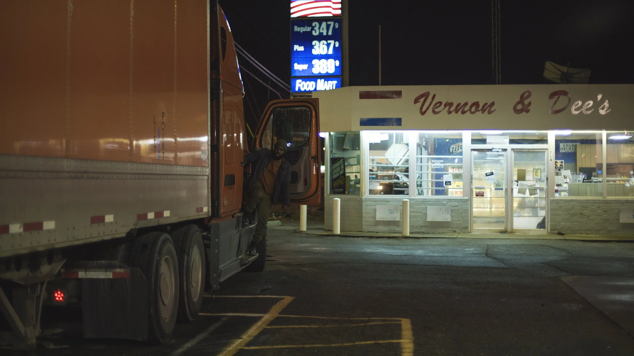 Trucker exiting cab at night by store