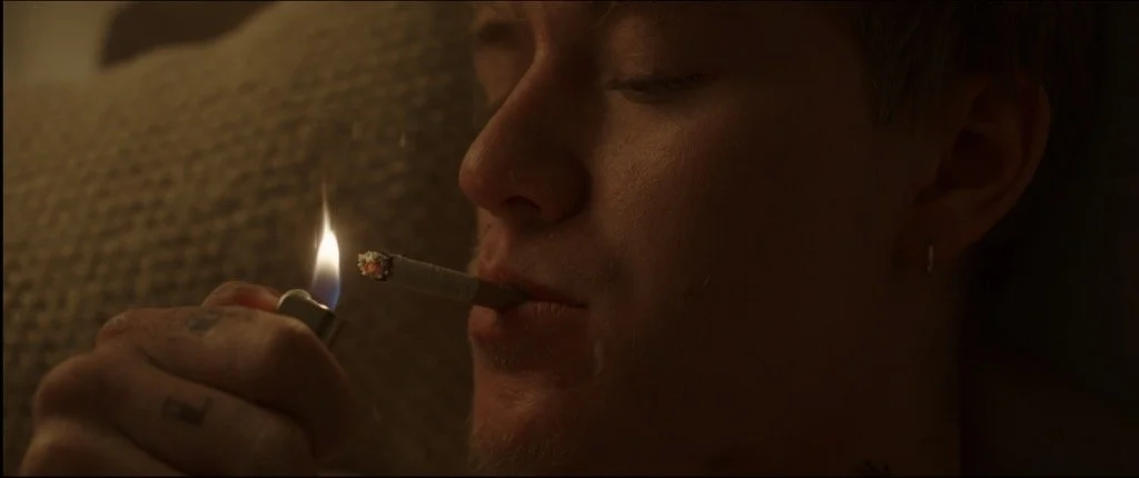 Person lighting a cigarette in a dim room