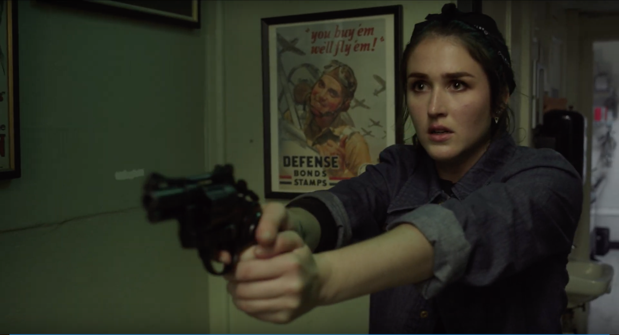 Woman aiming gun with tense expression.