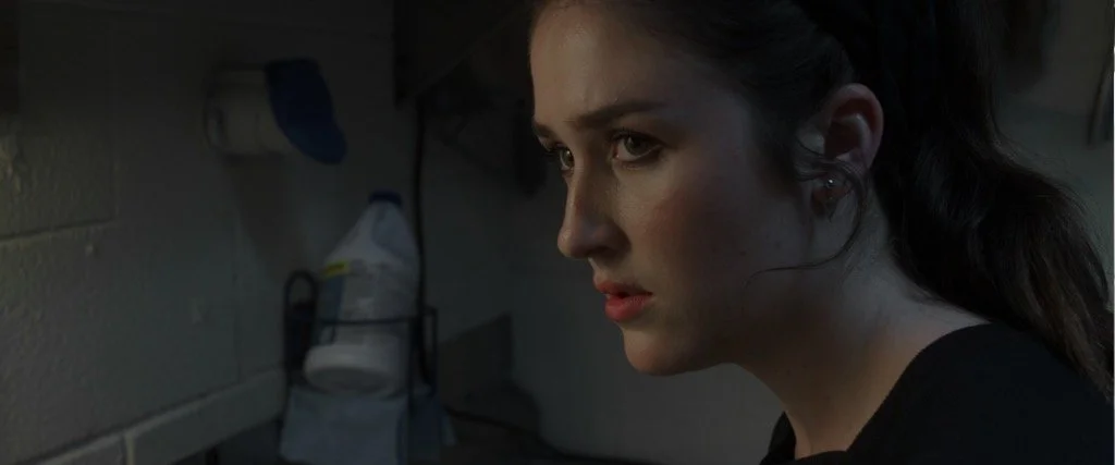 Woman looking sideways in a dim room.