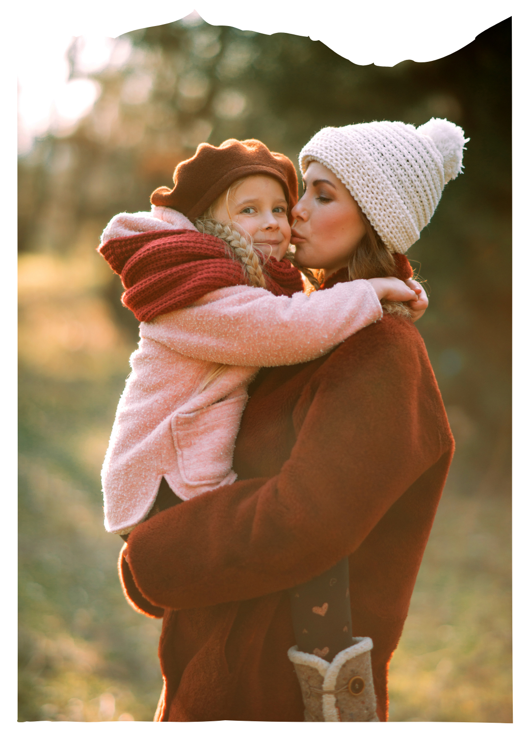 Mother hugging child outdoors in warm clothing during autumn