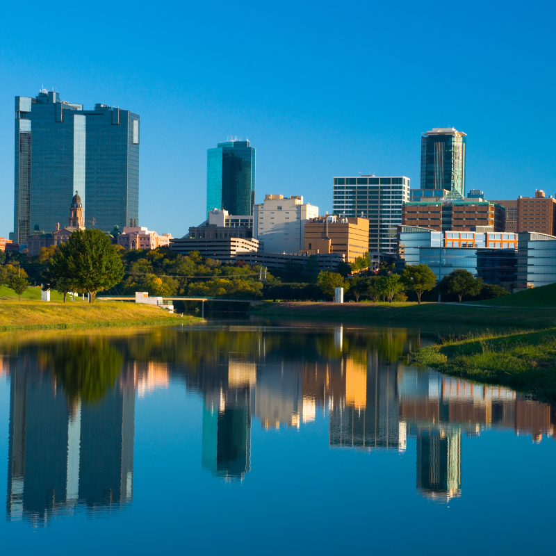 Fort Worth skyline reflected in Trinity River with city buildings and greenery